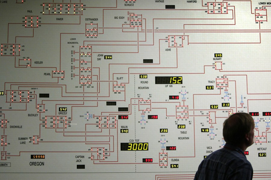 A figure looks at the dynamic map board showing power distribution through California's electrical grids in the control center of the California Independent System Operator. (Credit: David McNew/Getty Images)