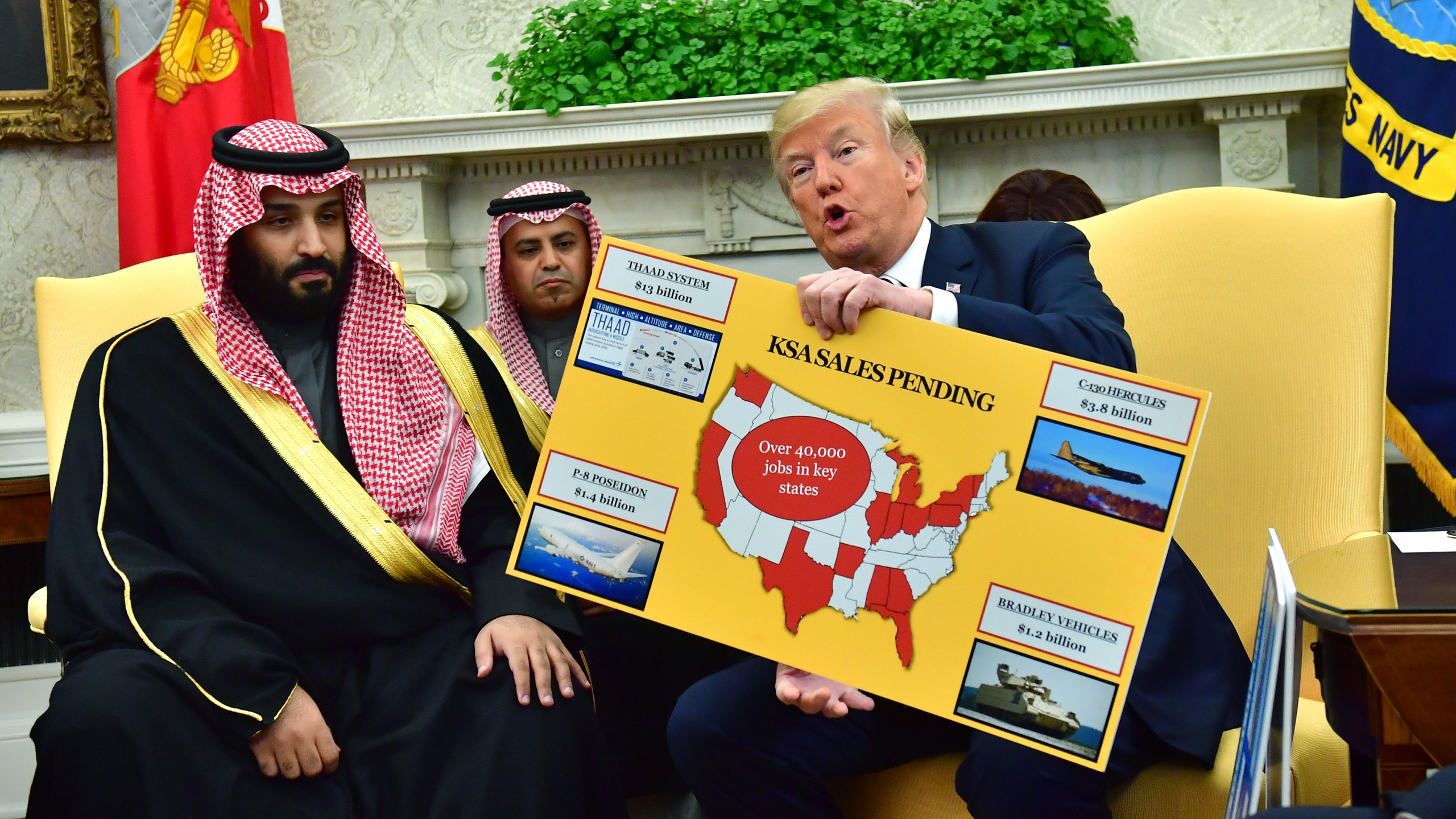 Donald Trump holds up a chart of military hardware sales as he meets with Crown Prince Mohammed bin Salman of Saudi Arabia at the White House on March 20, 2018, in Washington, D.C. (Credit: Kevin Dietsch-Pool/Getty Images)