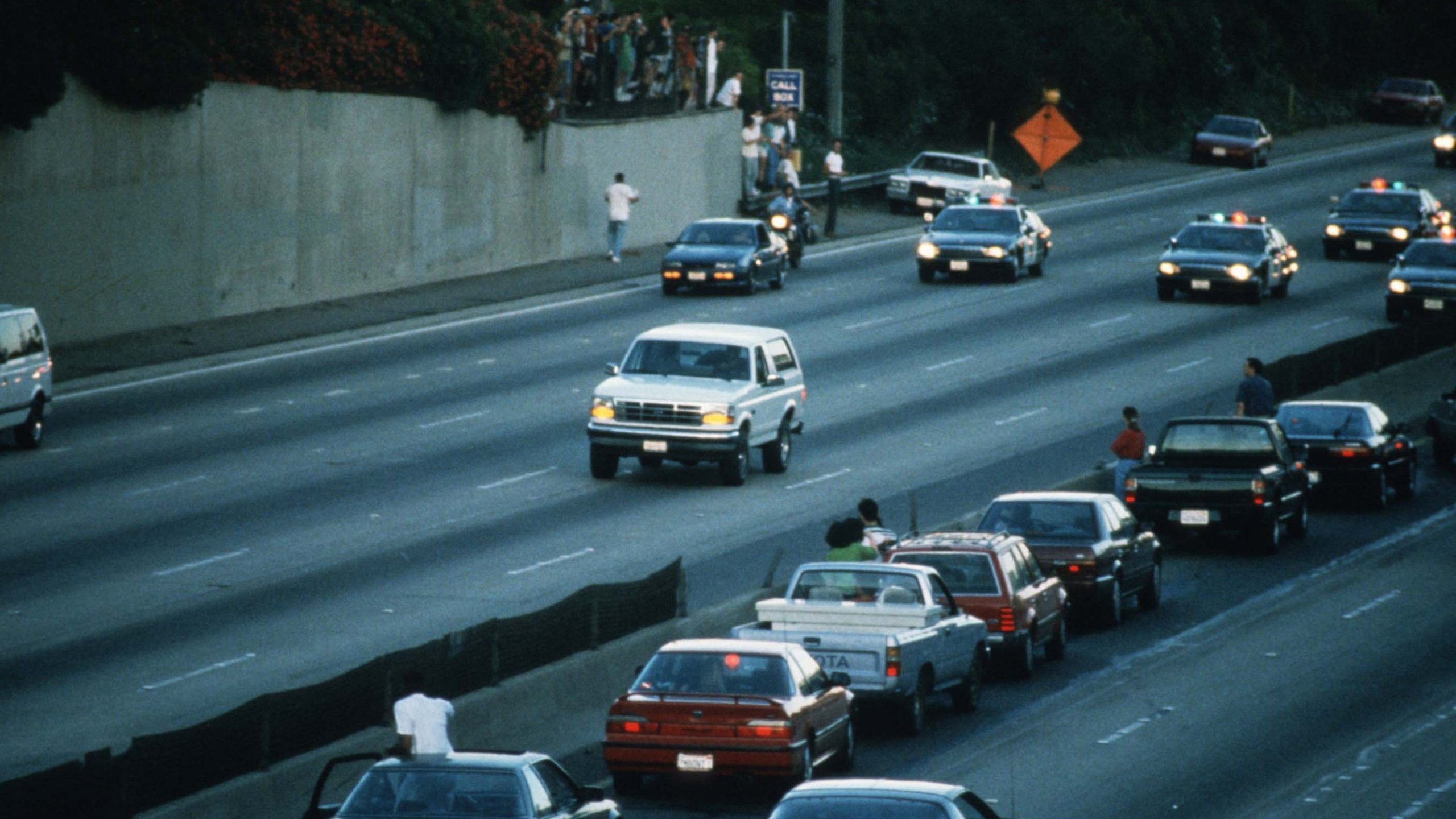 Motorists stop and wave as police cars pursue the white Ford Bronco on June 17, 1994. (Credit: Jean-Marc Giboux/Liason/Getty)