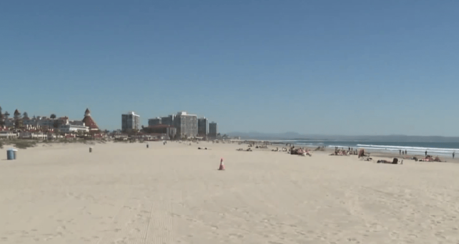 Beachgoers are seen on a beach in Coronado in July 2019. (Credit: KSWB)