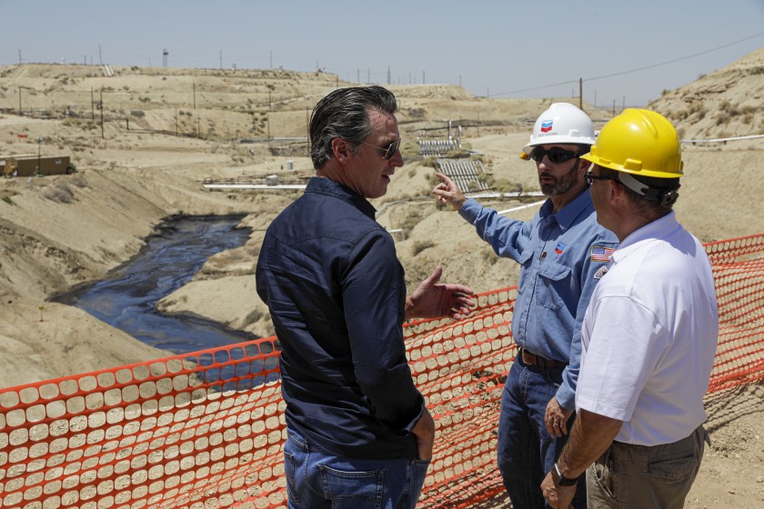 Gov. Gavin Newsom is briefed on a million-gallon spill in McKittrick by Billy Lacobie of Chevron, center, and Jason Marshall from the state Department of Conservation Division of Oil, Gas and Geothermal Resources on July 24, 2019. (Credit: Irfan Khan / Los Angeles Times )