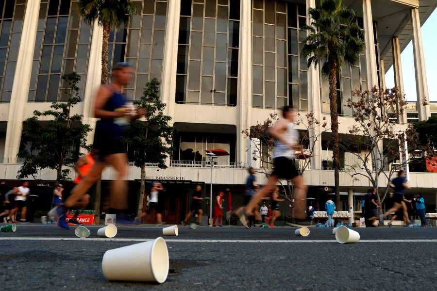 Competitors run past the Dorothy Chandler Pavilion during the 2019 Skechers Performance Los Angeles Marathon on March 24, 2019. (Credit: Katharine Lotze / Getty Images)