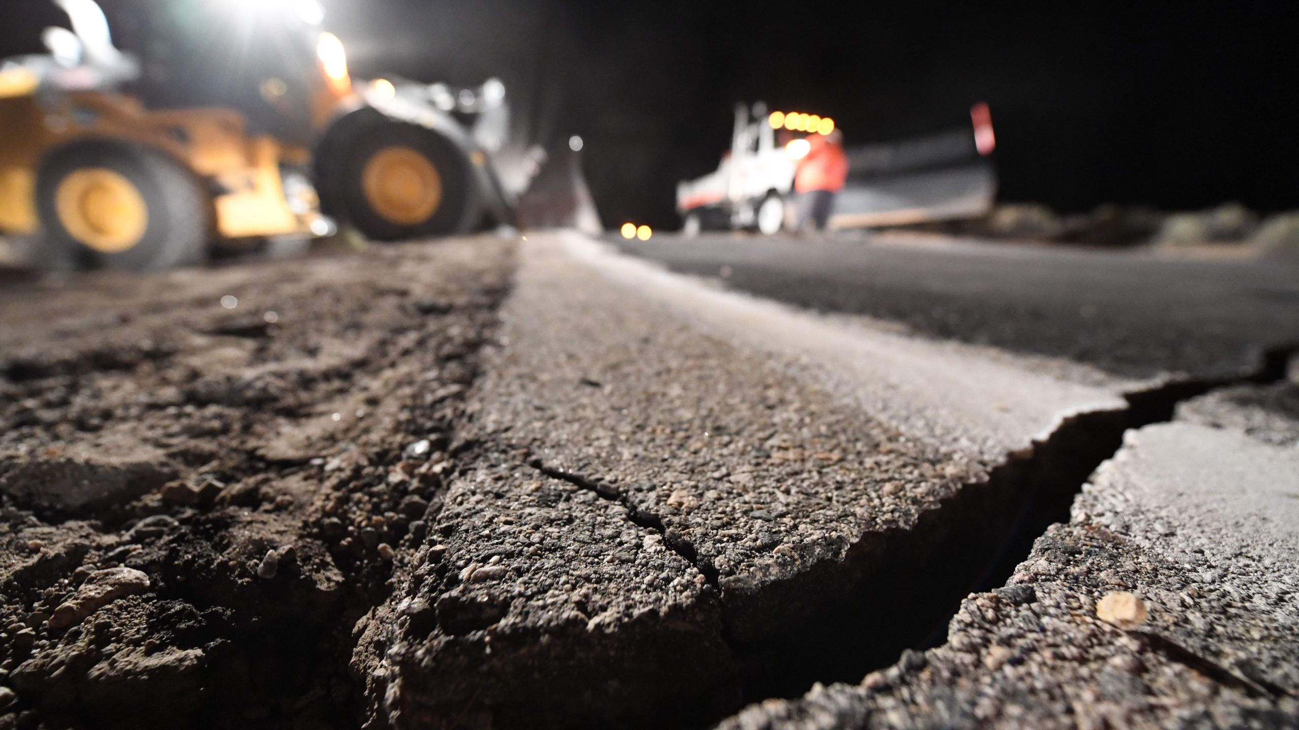 Highway workers repair a hole that opened in the road as a result of the July 5, 2019 earthquake, in Ridgecrest, California. (Credit: ROBYN BECK/AFP/Getty Images)