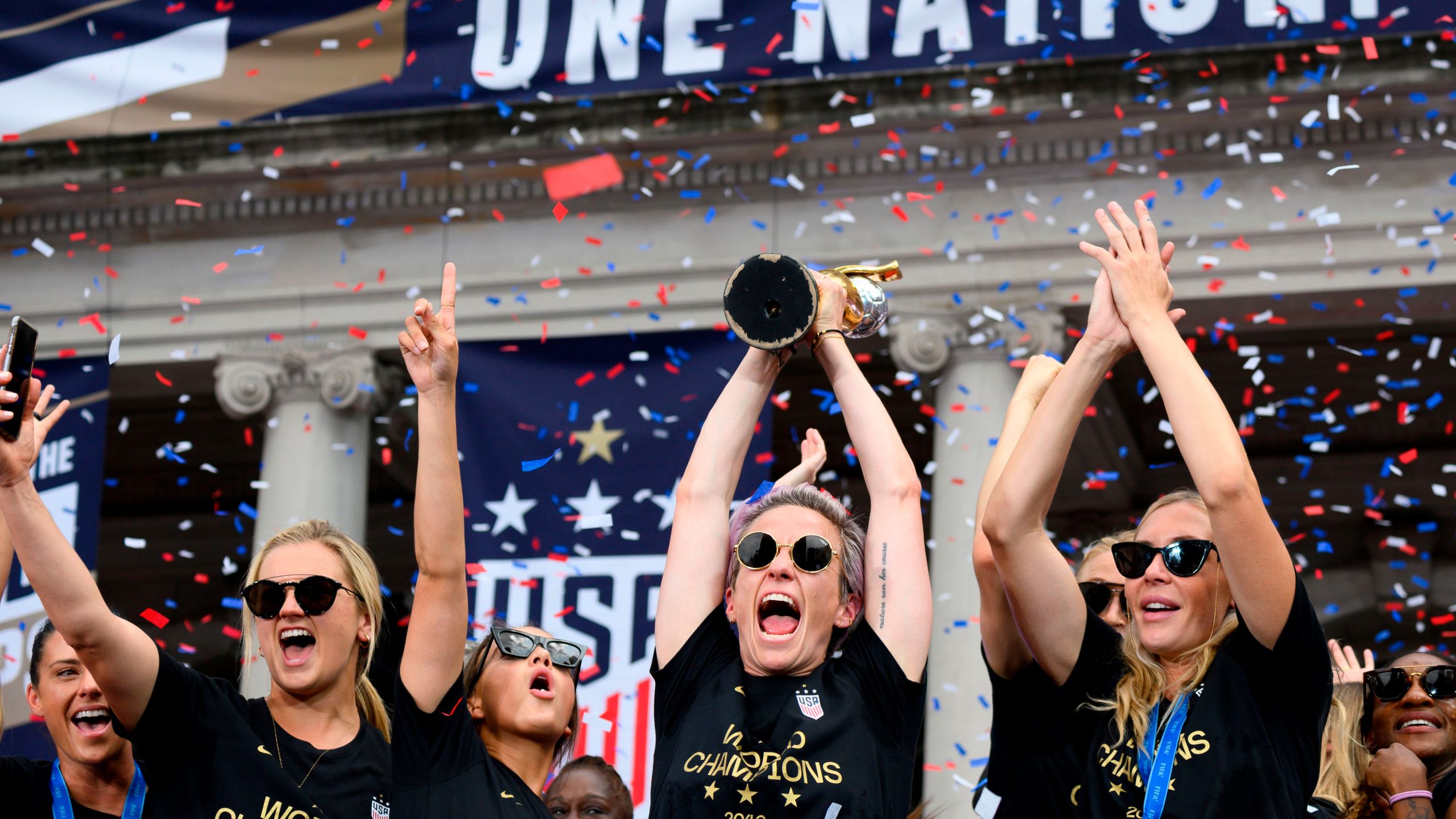 Megan Rapinoe and her team members celebrate with the trophy in front of the City Hall after the ticker tape parade for the women's World Cup champions on July 10, 2019 in New York. (Credit: JOHANNES EISELE/AFP/Getty Images)