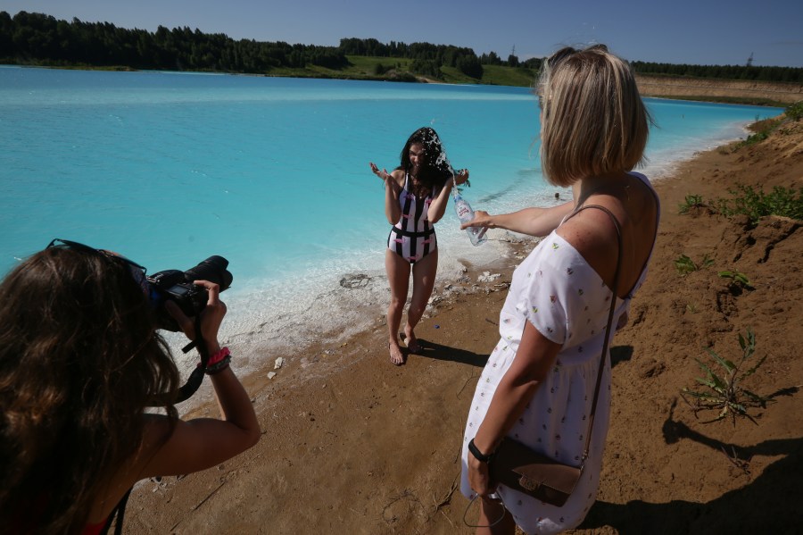 A young woman poses for pictures by a Novosibirsk energy plant's ash dump site that has been nicknamed "Maldives" by locals on July 11, 2019. (Credit: Rostislav Netisov/AFP/Getty Images)