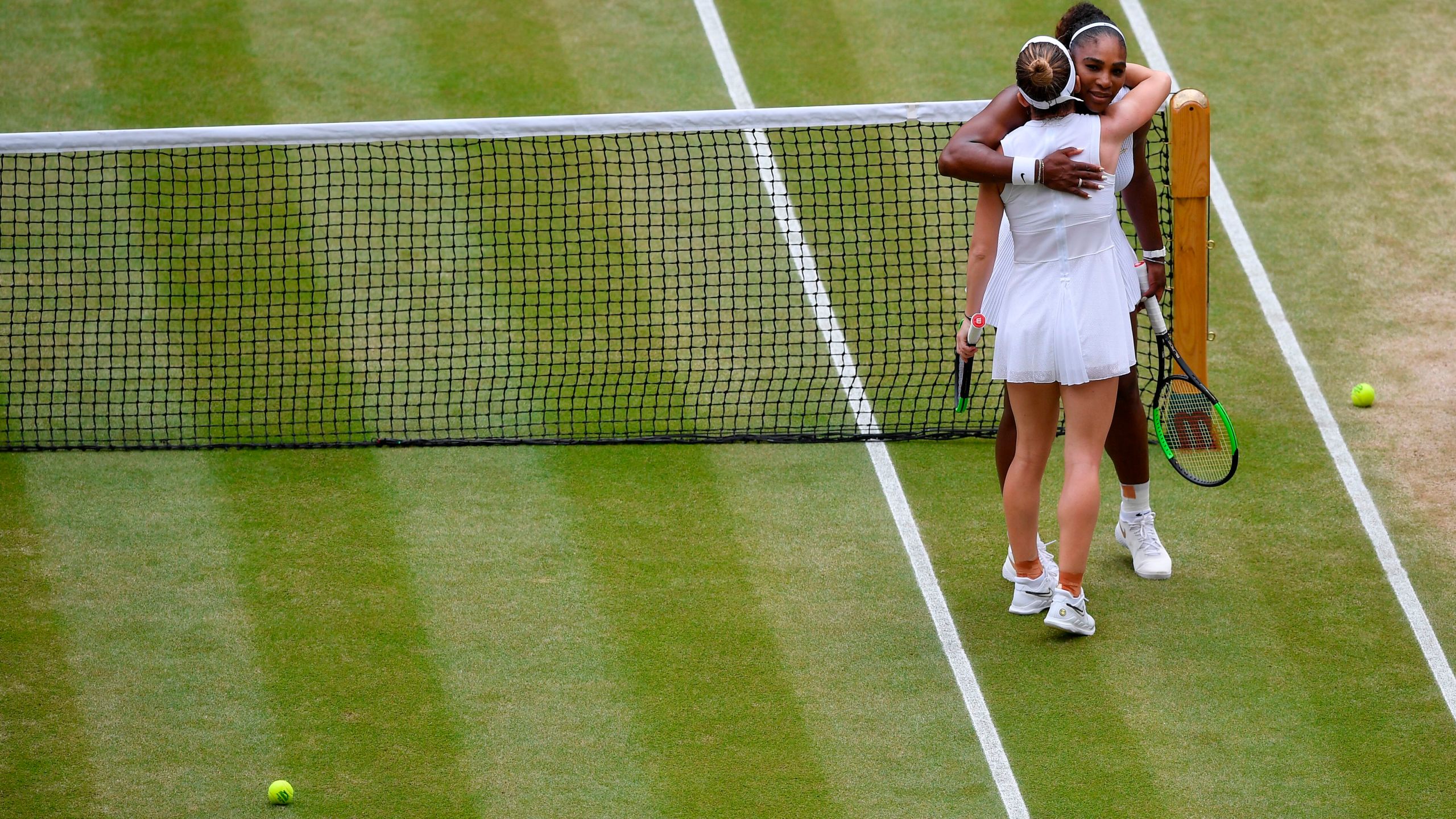 Romania's Simona Halep hugs U.S. player Serena Williams after beating her during their women's singles final on day 12 of the 2019 Wimbledon Championships at The All England Lawn Tennis Club in Wimbledon, southwest London, on July 13, 2019. (Credit: TOBY MELVILLE/AFP/Getty Images)