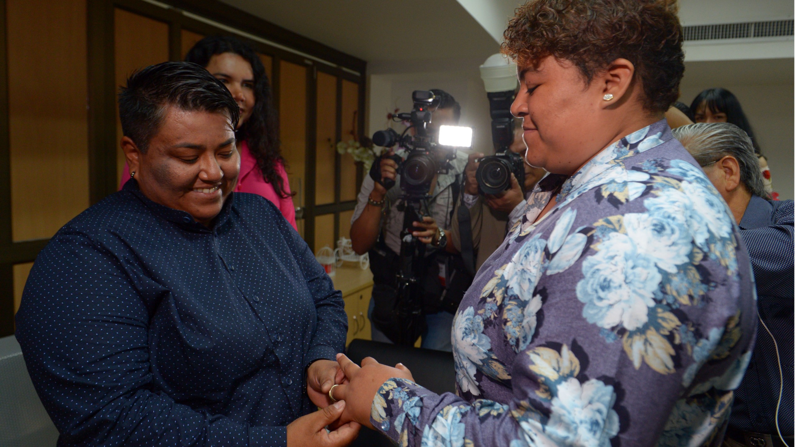 Alexandra Chavez (left) places a ring on the finger of Michelle Aviles during Ecuador's first same sex marriage at a registry office in Guayaquil on July 18, 2019. (Credit: MARCOS PIN/AFP/Getty Images)