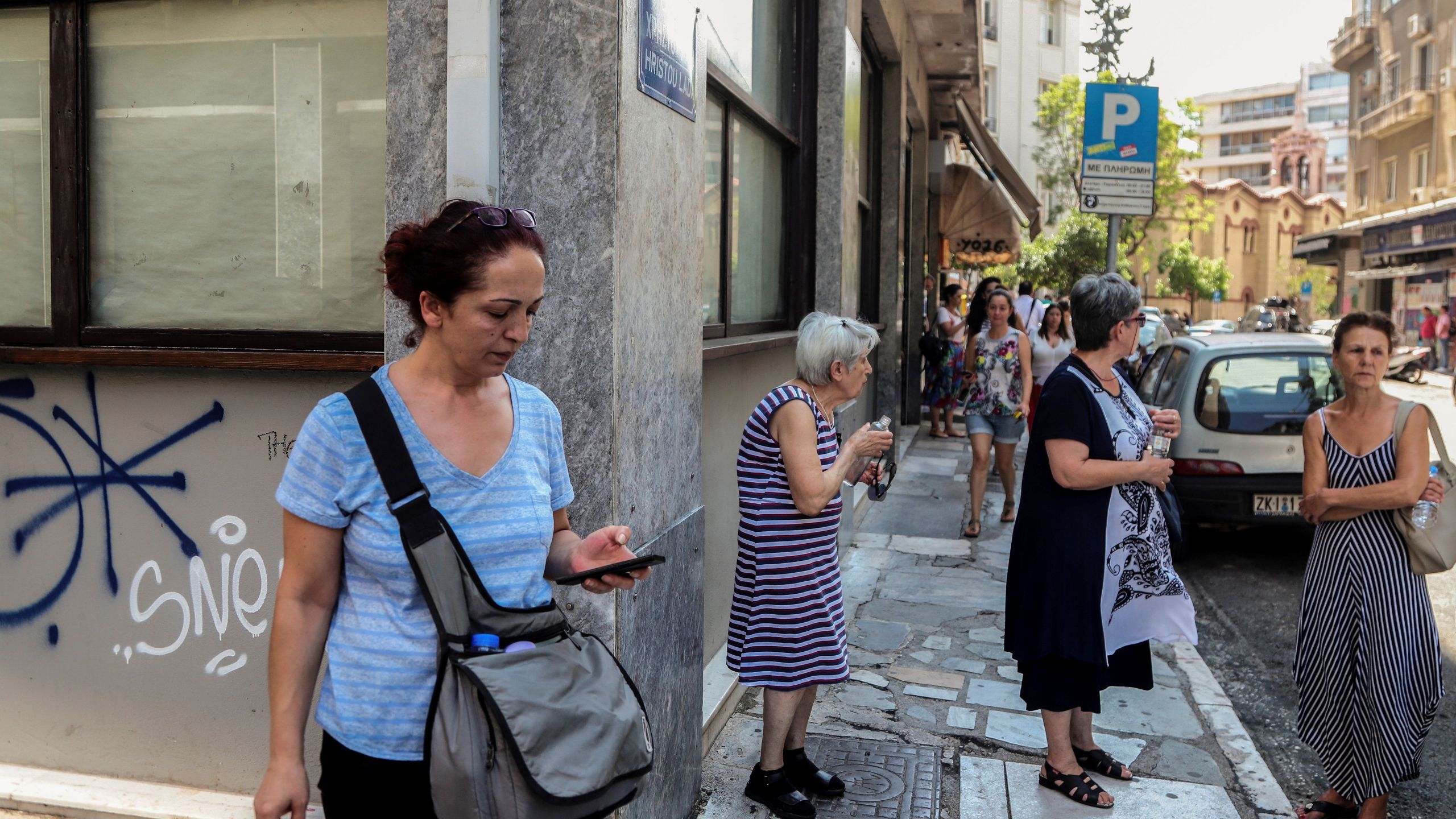 People stand outside buildings in central Athens after an earthquake on July 19, 2019. (Credit: EUROKINISSI/AFP/Getty Images)