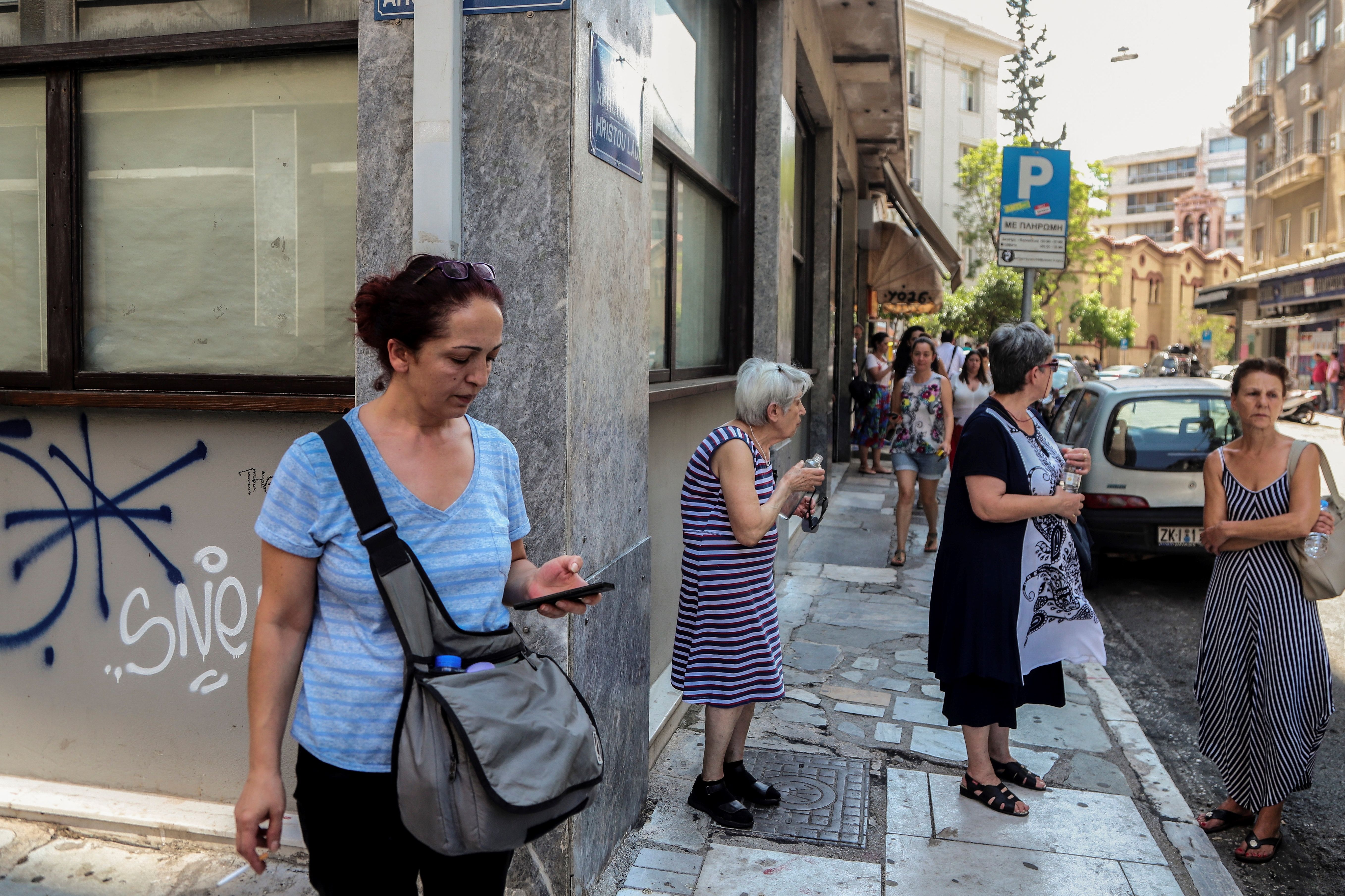 People stand outside buildings in central Athens after an earthquake on July 19, 2019. (Credit: EUROKINISSI/AFP/Getty Images)