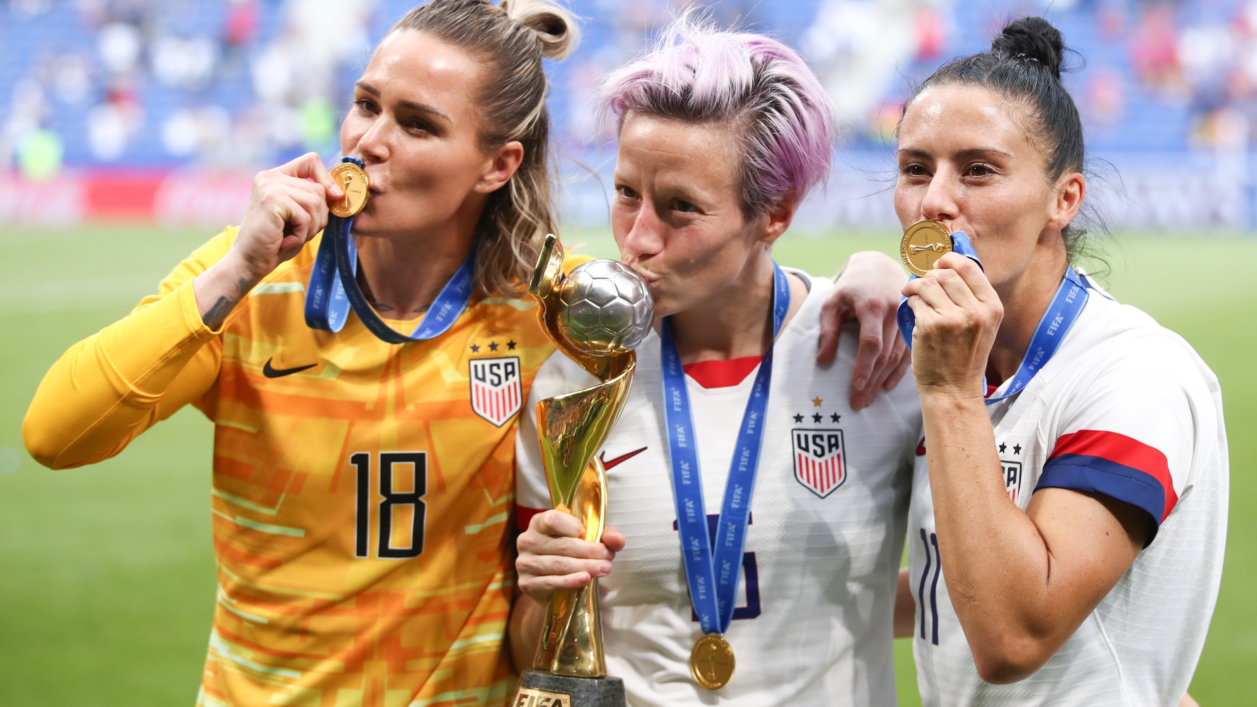 Ashlyn Harris, Megan Rapinoe and Ali Krieger of the U.S.A. Women's Soccer Team celebrate with the FIFA Women's World Cup Trophy following the 2019 FIFA Women's World Cup France Final match between the U.S. and the Netherlands at Stade de Lyon on July 7, 2019, in Lyon, France. (Credit: Alex Grimm/Getty Images)