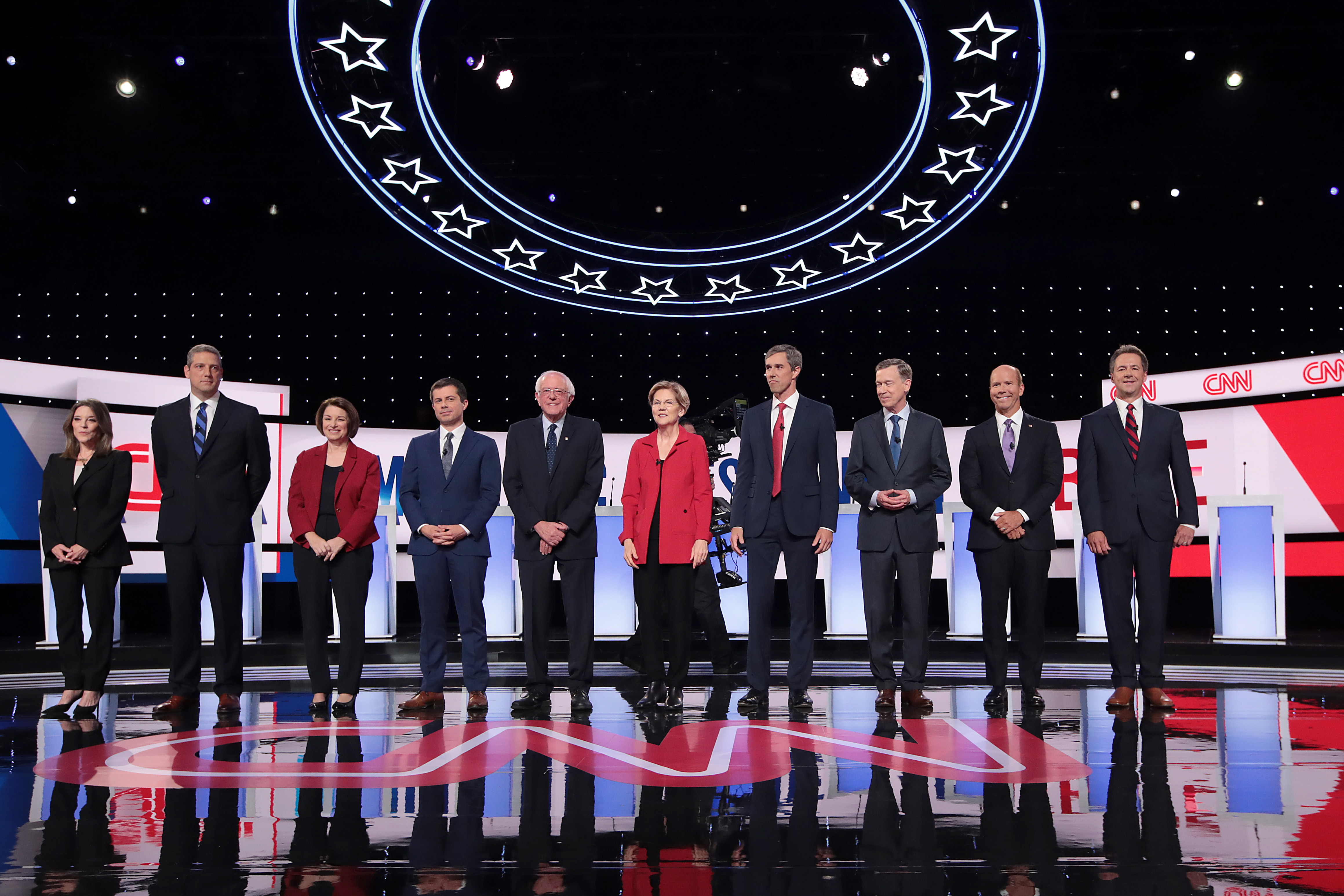 From left: Democratic presidential candidates Marianne Williamson, Rep. Tim Ryan, Sen. Amy Klobuchar, Indiana Mayor Pete Buttigieg, Sen. Bernie Sanders, Sen. Elizabeth Warren, former Texas congressman Beto O'Rourke, former Colorado governor John Hickenlooper, former Maryland congressman John Delaney and Montana Gov. Steve Bullock take the stage at the beginning of a CNN-hosted in Detroit on July 30, 2019. (Credit: Scott Olson / Getty Images)