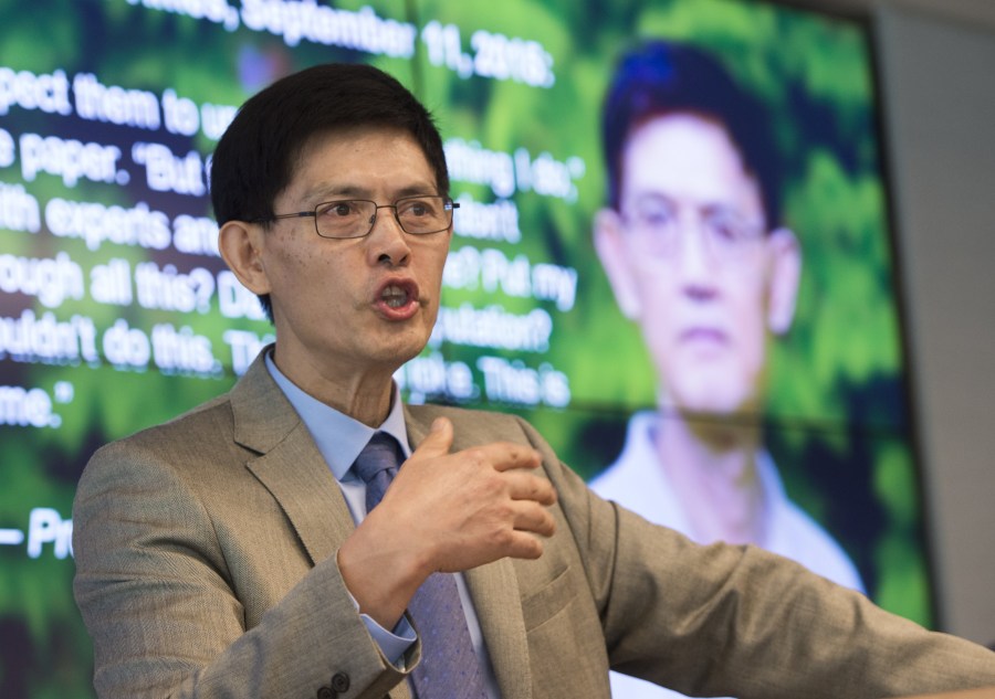 Xiaoxing Xi, chair of the Physics Department at Temple University, speaks alongside a photo of Sherry Chen (right), a U.S. federal government worker, about the dropped charges against them for spying for China, during a press conference in Washington, D.C., Sept. 15, 2015. (Credit: SAUL LOEB/AFP/Getty Images)