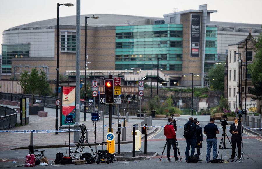 Journalists and television cameras stand by a police cordon near to the Manchester Arena in Manchester, northwest England on May 24, 2017, following the May 22 terror attack at the Manchester Arena. (Credit: CHRIS J RATCLIFFE/AFP/Getty Images)