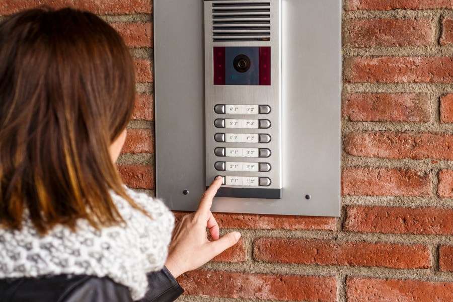 This file photo shows a woman facing a camera in an intercom panel outside a building.(Credit: iStock / Getty Images Plus)