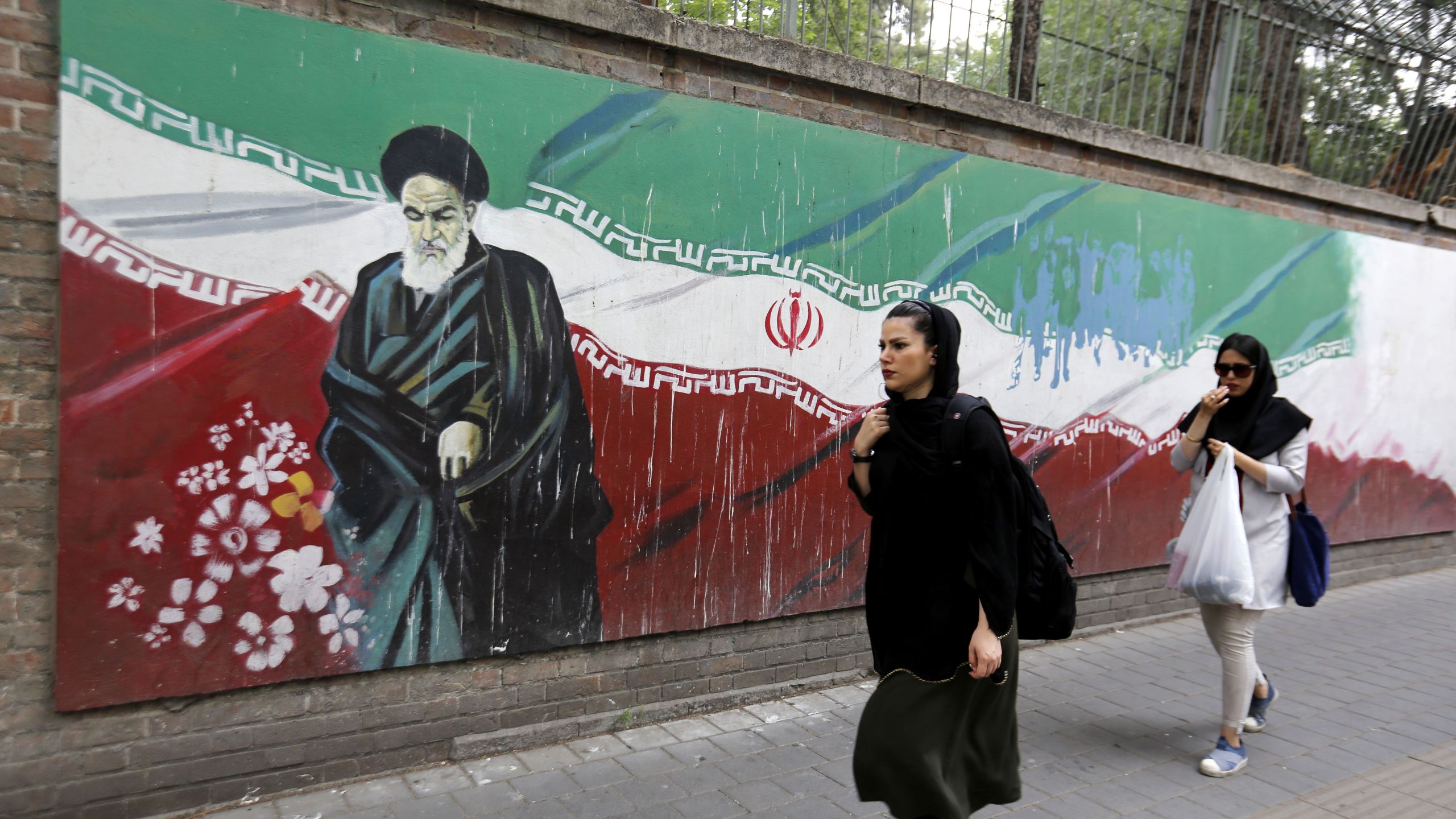 An Iranian woman walks past a mural on the wall of the former US embassy in the Iranian capital Tehran on May 8, 2018. (Credit: ATTA KENARE/AFP/Getty Images)