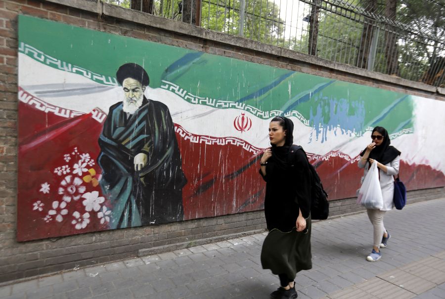 An Iranian woman walks past a mural on the wall of the former US embassy in the Iranian capital Tehran on May 8, 2018. (Credit: ATTA KENARE/AFP/Getty Images)