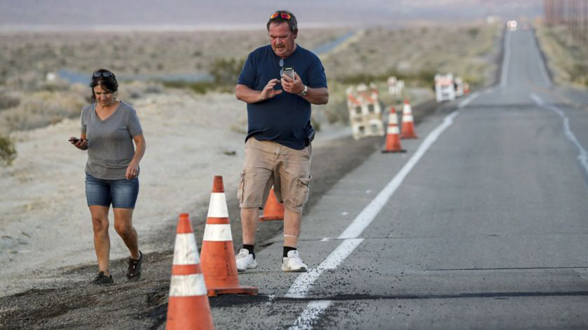 People survey the earthquake damage to roads in the Ridgecrest area. Recent aftershocks have headed southeast toward the Garlock fault, a lesser-known fault capable of producing an earthquake of magnitude 8 or more. The fault along the northern edge of the Mojave Desert can send shaking south and west into Bakersfield and Ventura and Los Angeles counties.(Credit: Irfan Khan / Los Angeles Times)