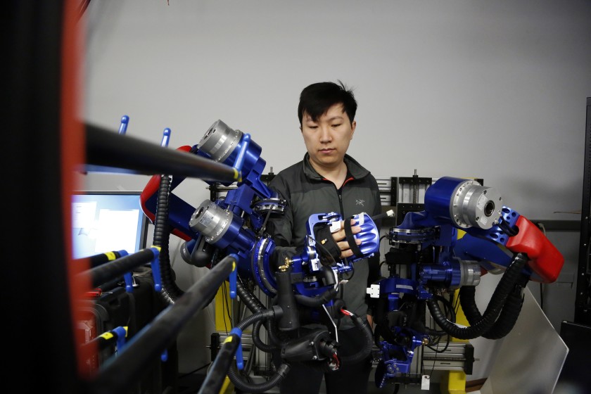 Yang Shen, a Ph.D. candidate in robotics at UCLA, demonstrates how the exoskeleton robot works in this undated photo. (Credit: Katie Falkenberg/Los Angeles Times)