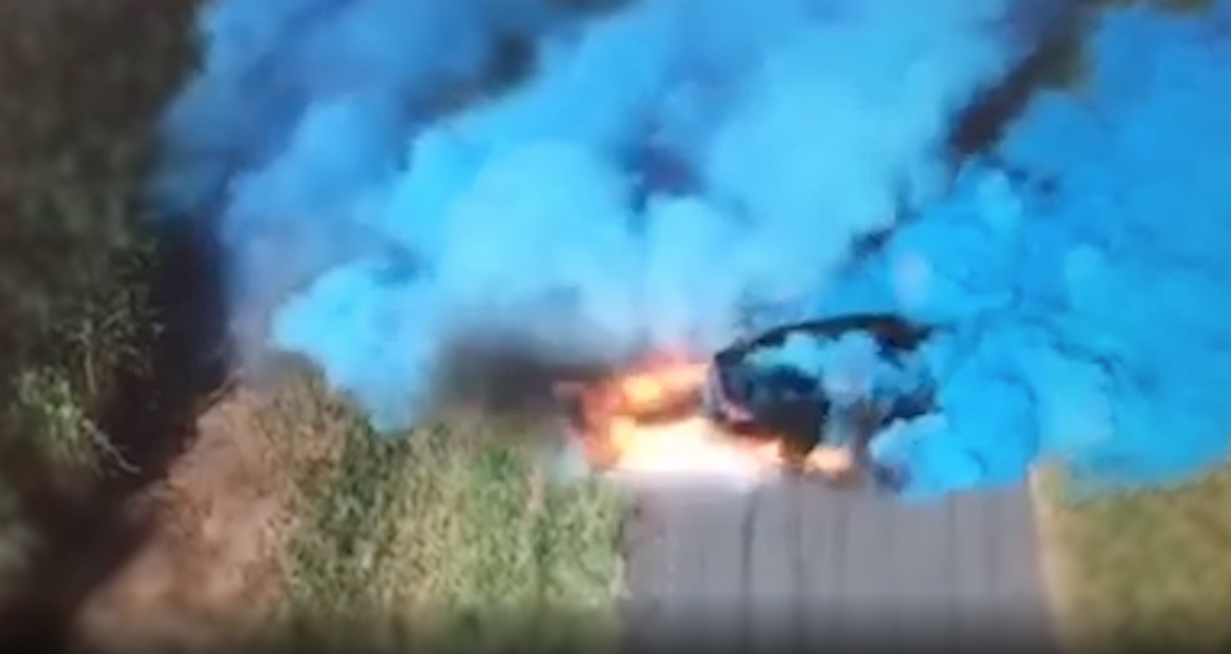 A still from a video released by the Queensland Police Service in July 2019 shows a car emitting blue smoke during a gender reveal party.