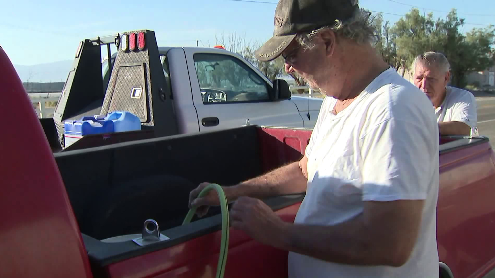 A Trona man fills up containers with water from a truck brought into town by the Searles Domestic Water Co. on July 9, 2019. (Credit: KTLA)