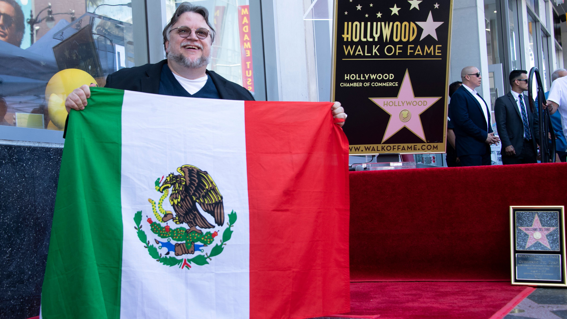 Director Guillermo Del Toro poses with the Mexican flag during the ceremony for his Star on the Hollywood Walk of Fame on Aug. 6, 2019. (Credit: Valerie Macon/AFP/Getty Images)