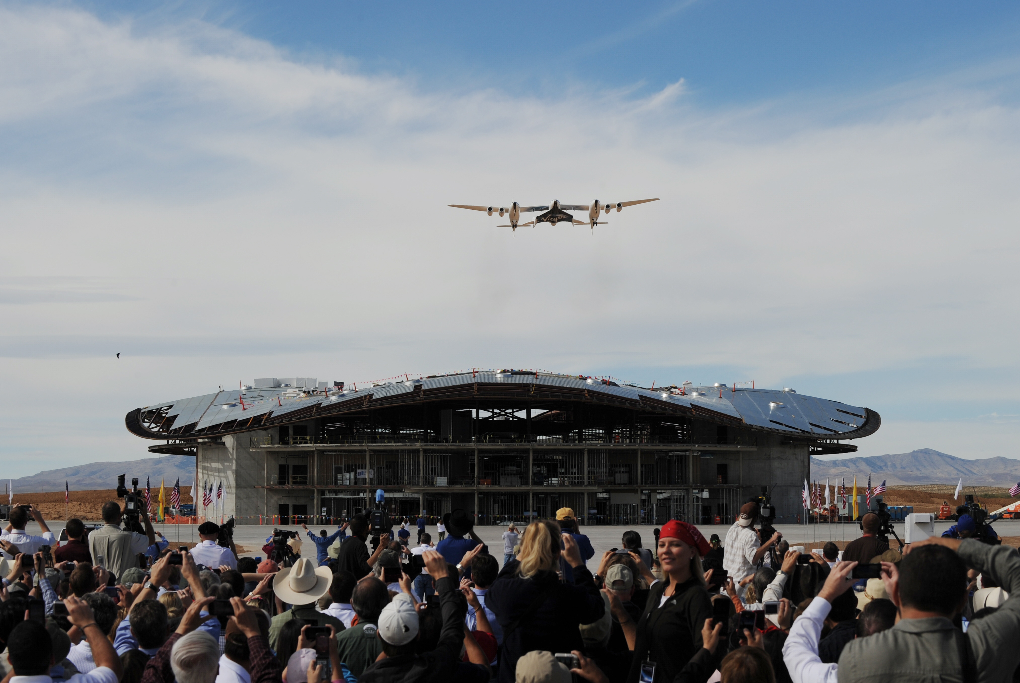 The Virgin Galactic VSS Enterprise spacecraft flies over its hanger before its first public landing during the Spaceport America runway dedication ceremony near Las Cruces, New Mexico on October 22, 2010. (Credit: MARK RALSTON/AFP/Getty Images)