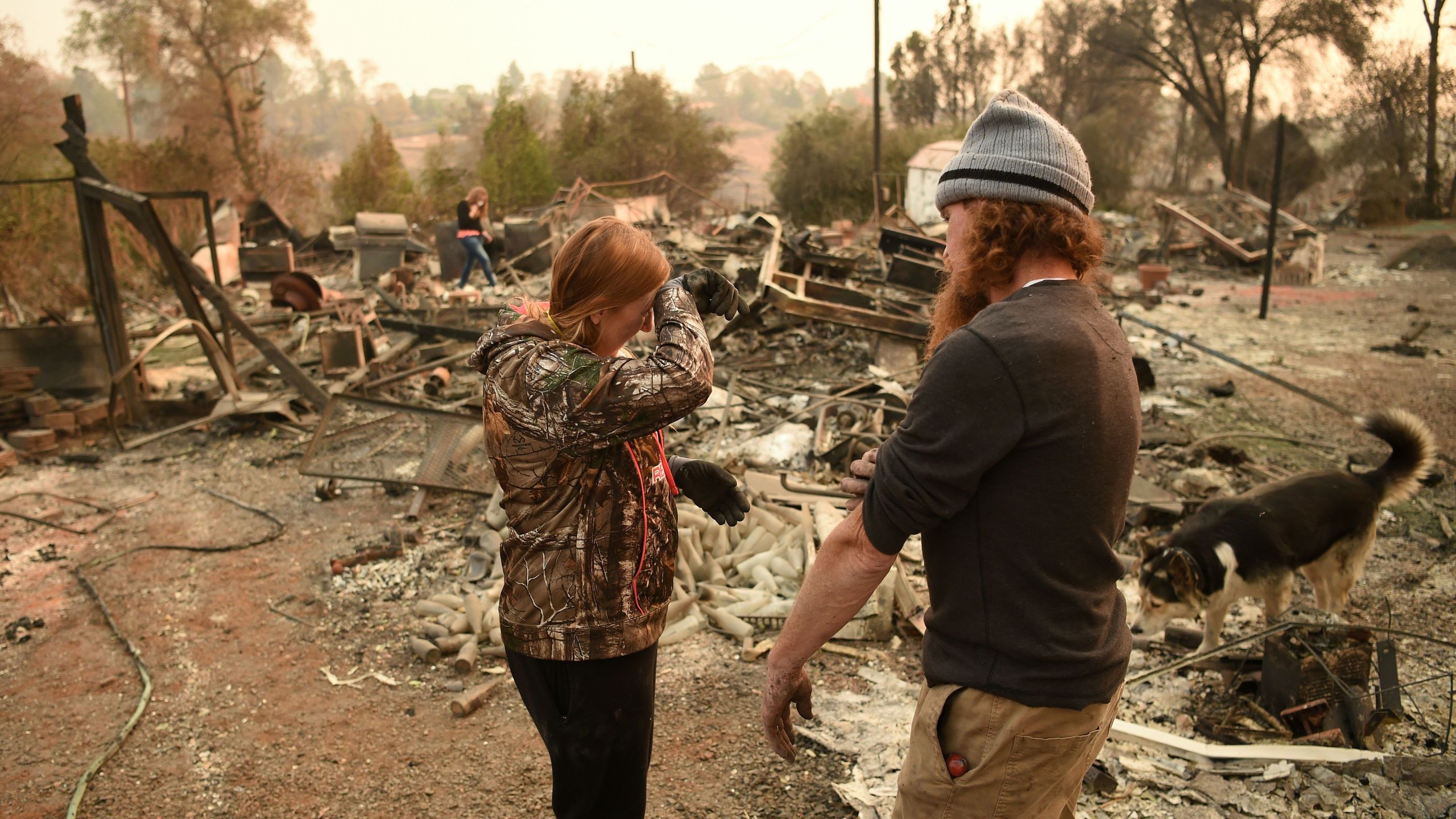 Kimberly Spainhower and her husband Ryan Spainhower weep while searching through the ashes of their burned home in Paradise, California on Nov. 18, 2018. (Credit: JOSH EDELSON/AFP/Getty Images)