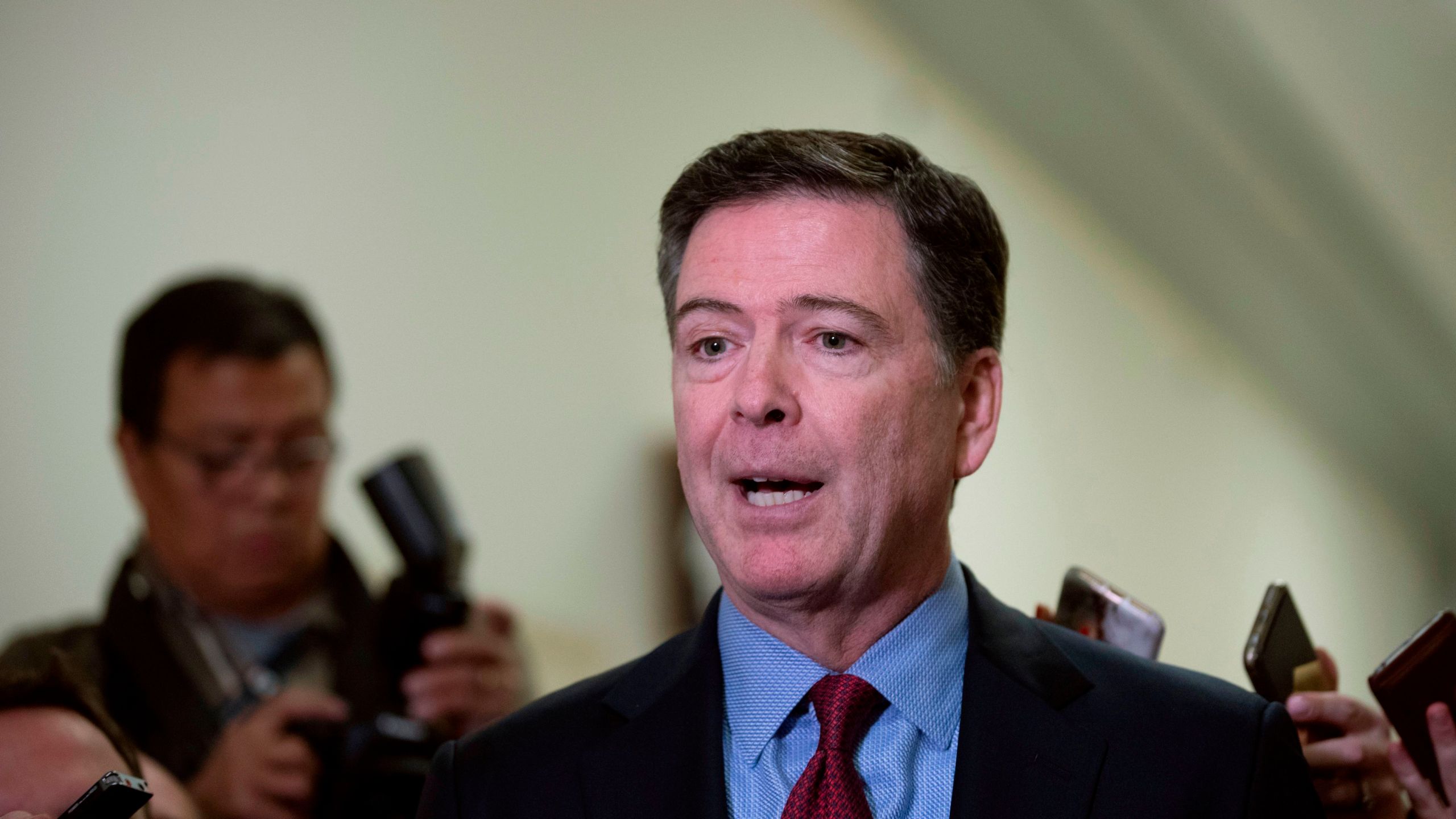 Former FBI Director James Comey (C) talks to reporters following a closed House Judiciary Committee meeting to hear his testimony, on Capitol Hill in Washington, DC, on December 7, 2018. (Credit: ALEX EDELMAN/AFP/Getty Images)