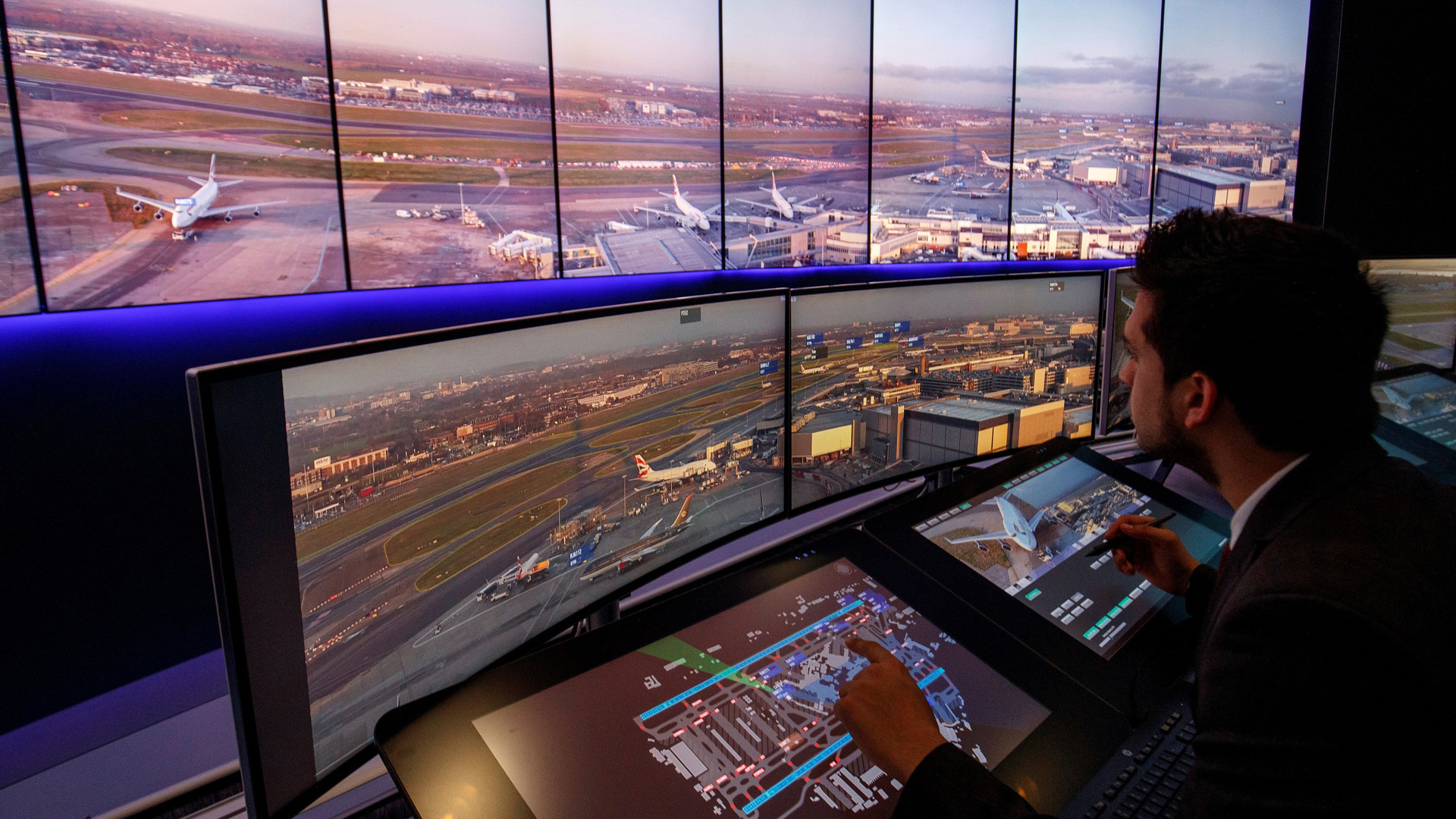 Air traffic control engineers watch screens displaying real-time views of runways and docking gates filmed through cameras combined with artificial intelligence at London Heathrow Airport in west London on Jan. 23, 2019.(Credit: Tolga Akmen/AFP/Getty Images)