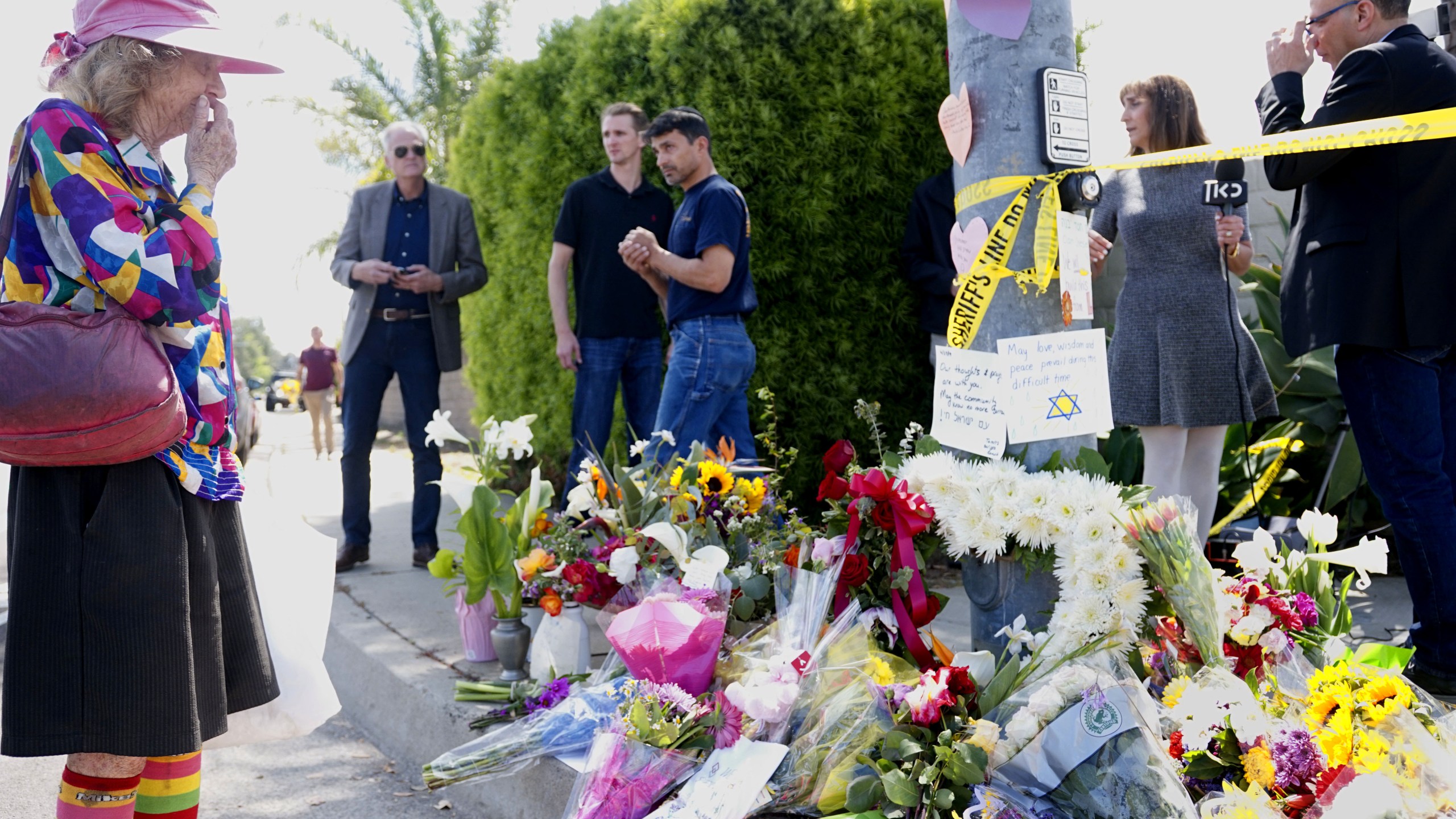 Mourners and well-wishers leave flowers at a makeshift memorial across the street from the Chabad of Poway synagogue on April 28, 2019, one day after a teenage gunman opened fire, killing one person and injuring three others including the rabbi. (Credit: Sandy Huffaker / AFP / Getty Images)