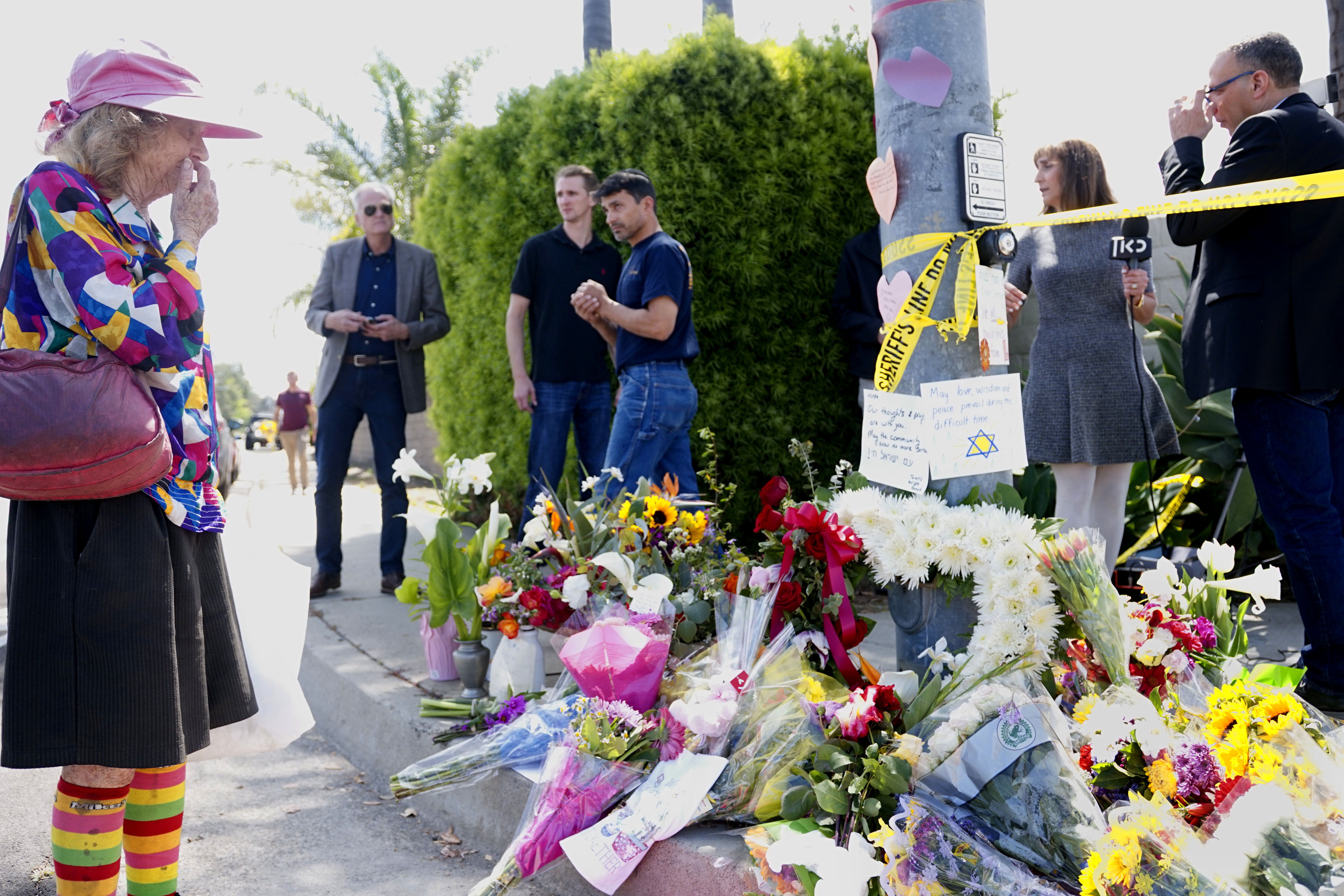 Mourners and well-wishers leave flowers at a makeshift memorial across the street from the Chabad of Poway synagogue on April 28, 2019, one day after a teenage gunman opened fire, killing one person and injuring three others including the rabbi. (Credit: Sandy Huffaker / AFP / Getty Images)