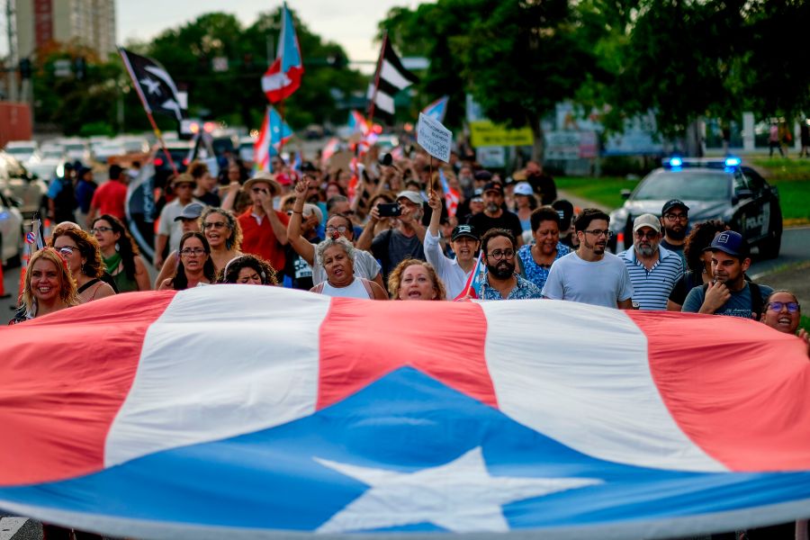 People march in protest in San Juan on July 29, 2019, against Wanda Vazquez, Puerto Rico's current Secretary of Justice, possibly becoming governor. She later rejected the job. (Credit: RICARDO ARDUENGO/AFP/Getty Images)