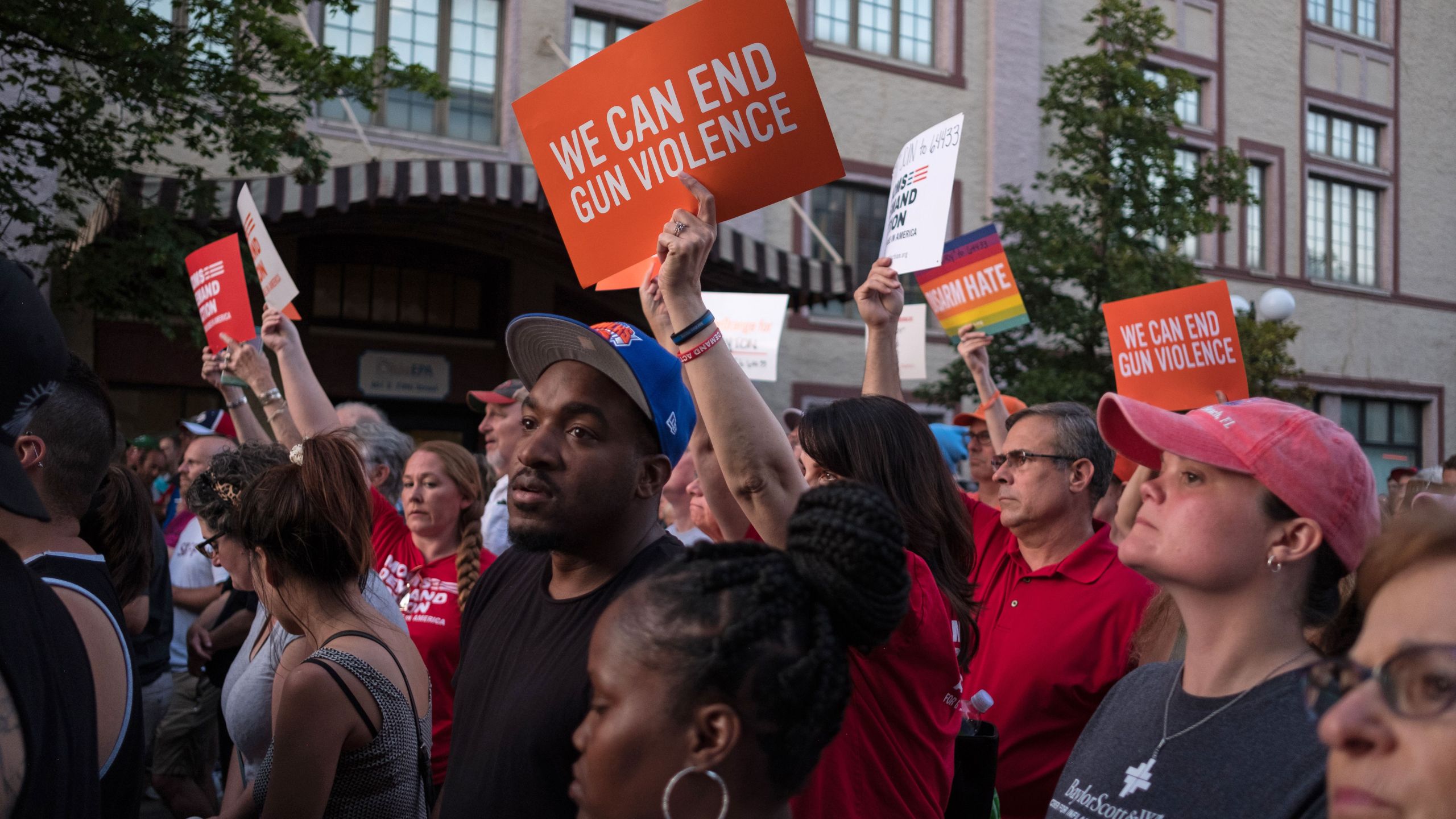 People hold signs as they take part of a candle lit vigil in honor of those who lost their lives or were wounded in a shooting in Dayton, Ohio on August 4, 2019. (Credit: MEGAN JELINGER/AFP/Getty Images)