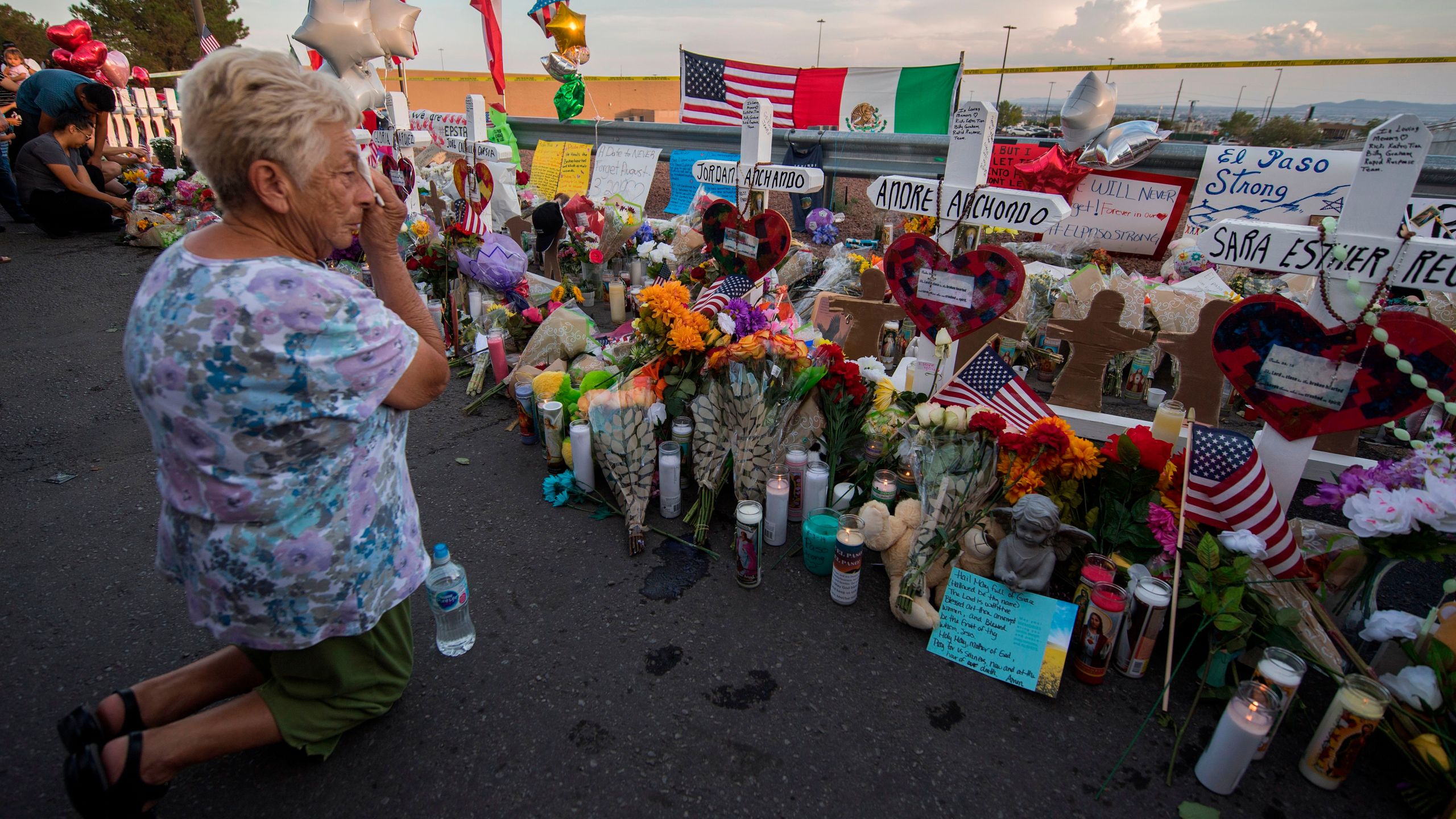 A woman prays at a makeshift memorial for victims of Walmart shooting that left a total of 22 people dead at the Cielo Vista Mall WalMart in El Paso, Texas, sometime in the days after the massacre on Aug. 5, 2019. (Credit: MARK RALSTON/AFP/Getty Images)