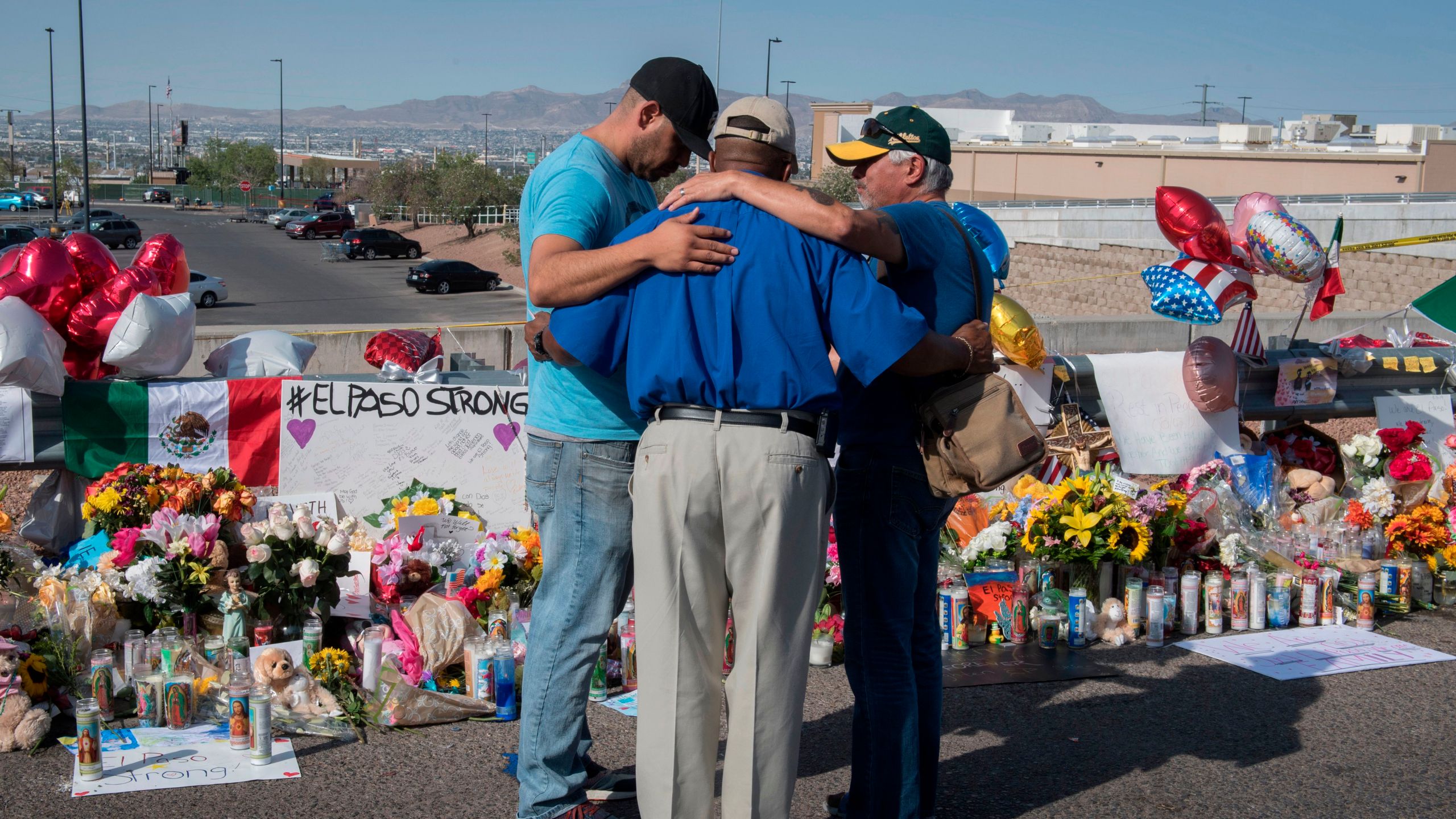 People pray at the makeshift memorial on Aug. 7, 2019, for victims of the shooting that left 22 people dead at a Walmart in El Paso, Texas. (Credit: Mark Ralston / AFP / Getty Images)