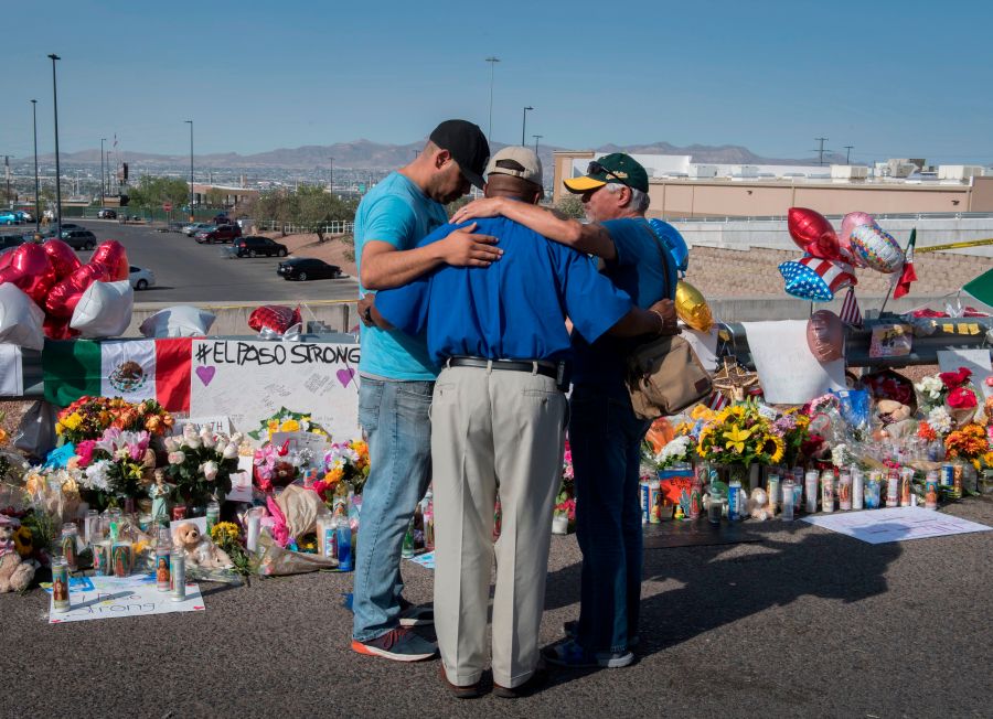 People pray at the makeshift memorial on Aug. 7, 2019, for victims of the shooting that left 22 people dead at a Walmart in El Paso, Texas. (Credit: Mark Ralston / AFP / Getty Images)