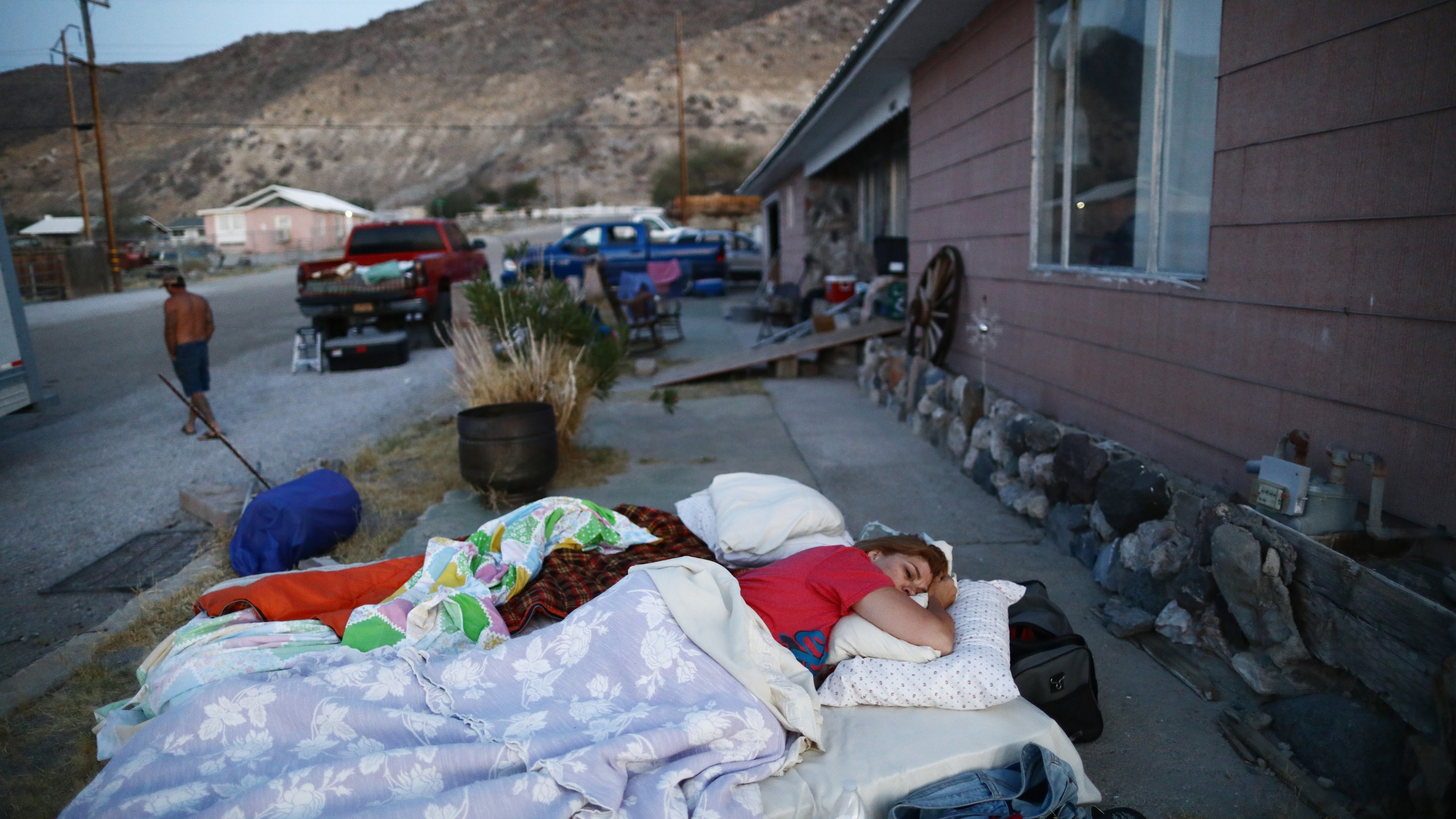 Chimene Jackson sleeps shortly after dawn outside her parents' home, which has been deemed uninhabitable due to structural damage from the recent 7.1 magnitude earthquake, on July 8, 2019 in Trona, Calif. (Credit: Mario Tama/Getty Images)