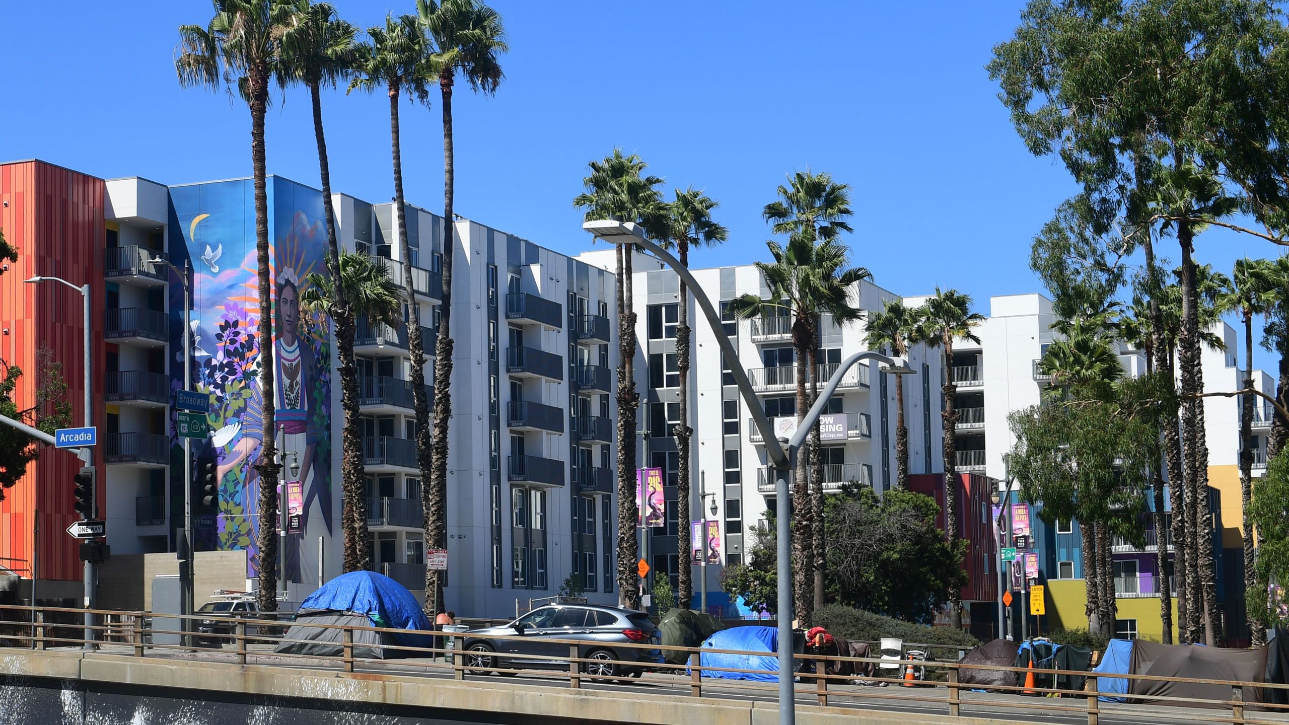 Tents belonging to homeless people are seen by new high-rise developments alongside a freeway ramp in downtown Los Angeles on Aug. 14, 2019. (Credit: FREDERIC J. BROWN/AFP/Getty Images)