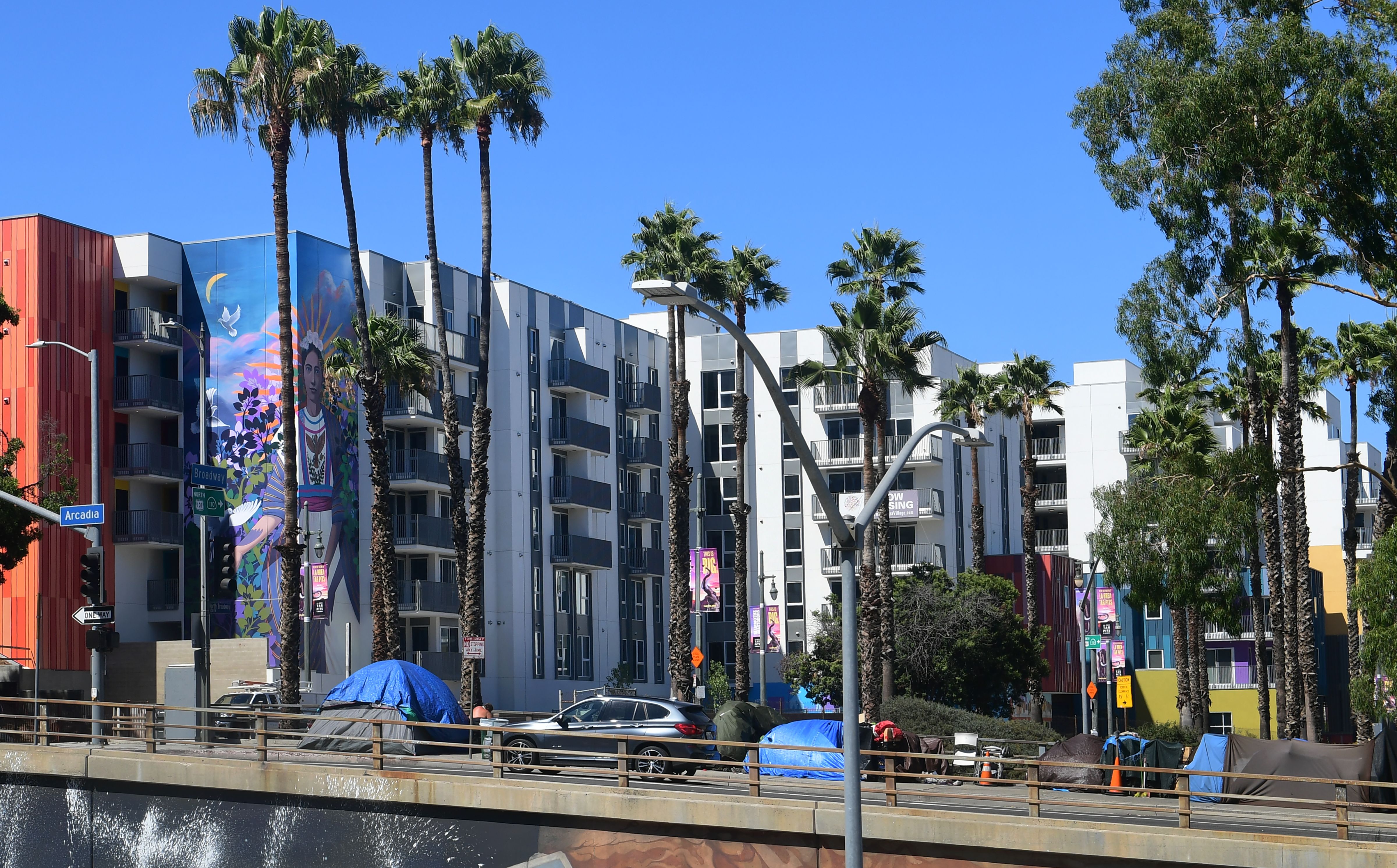 Tents belonging to homeless people are seen by new high-rise developments alongside a freeway ramp in downtown Los Angeles on Aug. 14, 2019. (Credit: FREDERIC J. BROWN/AFP/Getty Images)