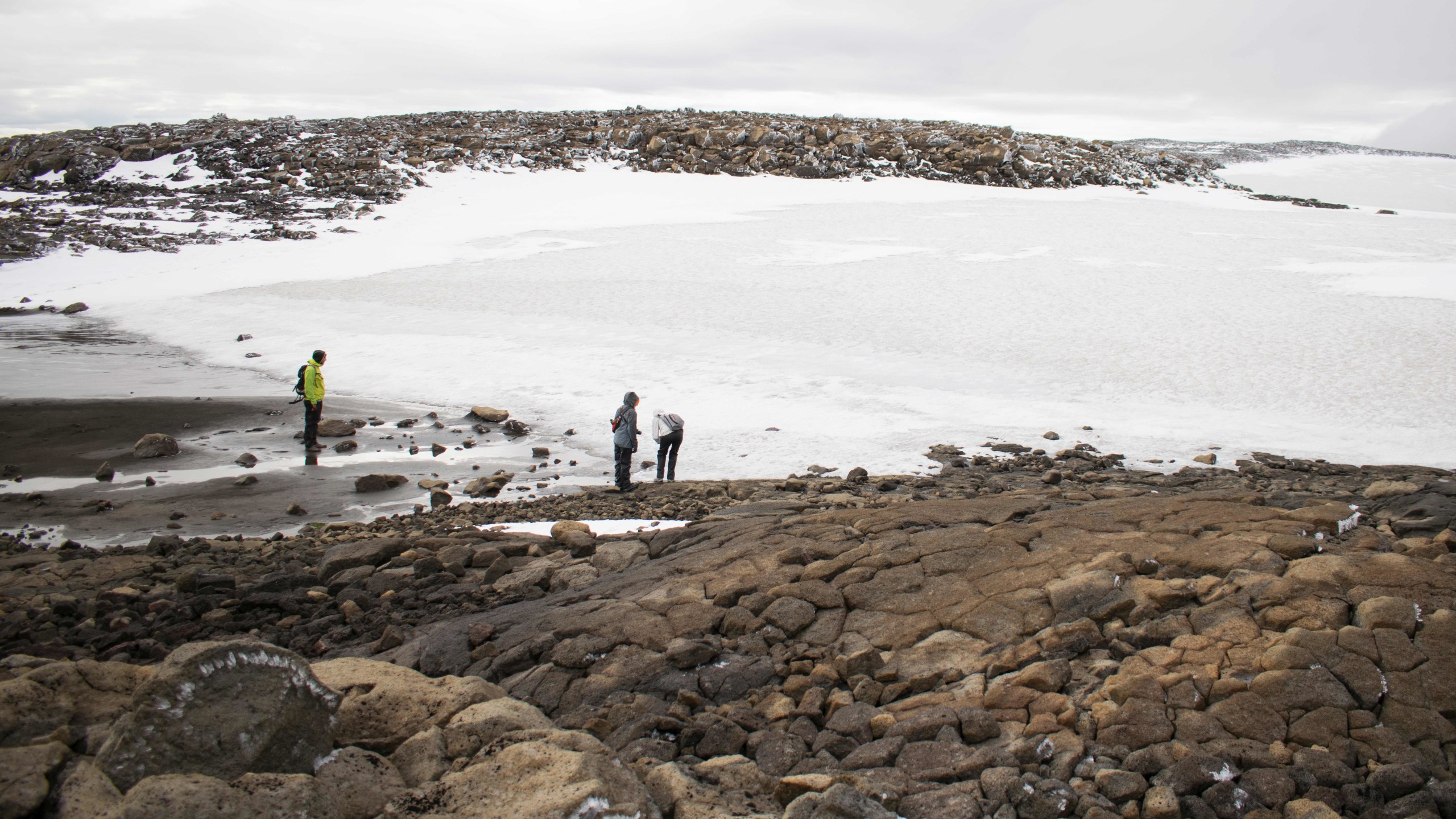 People look at the snow after a monument was unveiled at the site of Okjokull, Iceland's first glacier lost to climate change, on Aug. 18, 2019. (Credit: JEREMIE RICHARD/AFP/Getty Images)