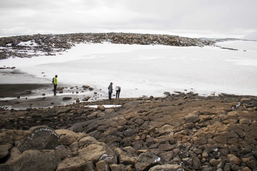 People look at the snow after a monument was unveiled at the site of Okjokull, Iceland's first glacier lost to climate change, on Aug. 18, 2019. (Credit: JEREMIE RICHARD/AFP/Getty Images)