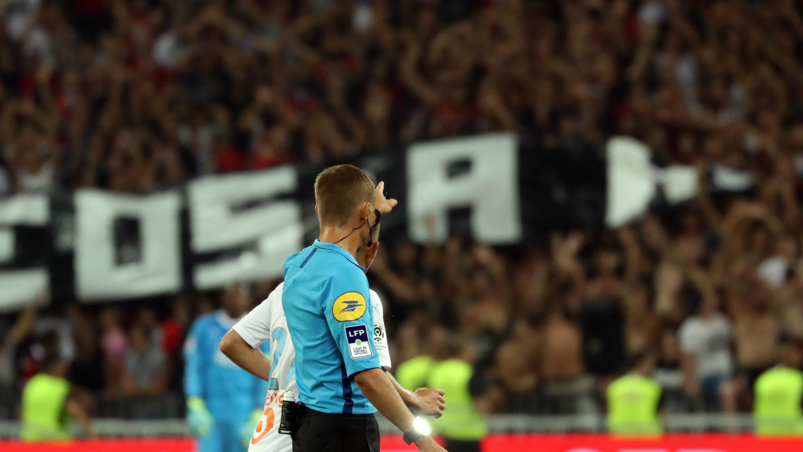 French referee Clement Turpin gestures as he halts the game after supporters shouted homophobic songs and brandished banners during the football match between OGC Nice and Olympique de Marseille on August 28, 2019 in southeastern France. (Credit: VALERY HACHE/AFP/Getty Images)