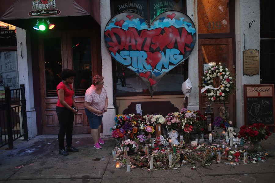 People look over a memorial to those killed in a mass shooting while the businesses along E. 5th Street in the Oregon District try to return to normal on Aug. 6, 2019, in Dayton, Ohio. (Credit: Scott Olson/ Getty Images)