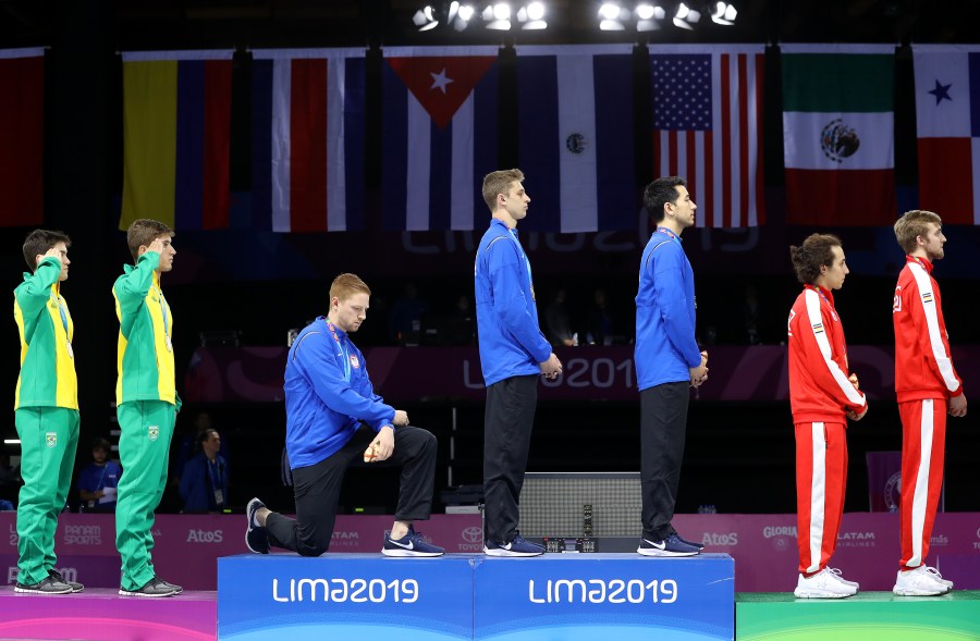 Gold medalist Race Imboden takes a knee during the national anthem ceremony in the 2019 Pan American Games at Fencing Pavilion of Lima Convention Center on Aug. 9, 2019 in Peru. (Credit: Leonardo Fernandez/Getty Images)