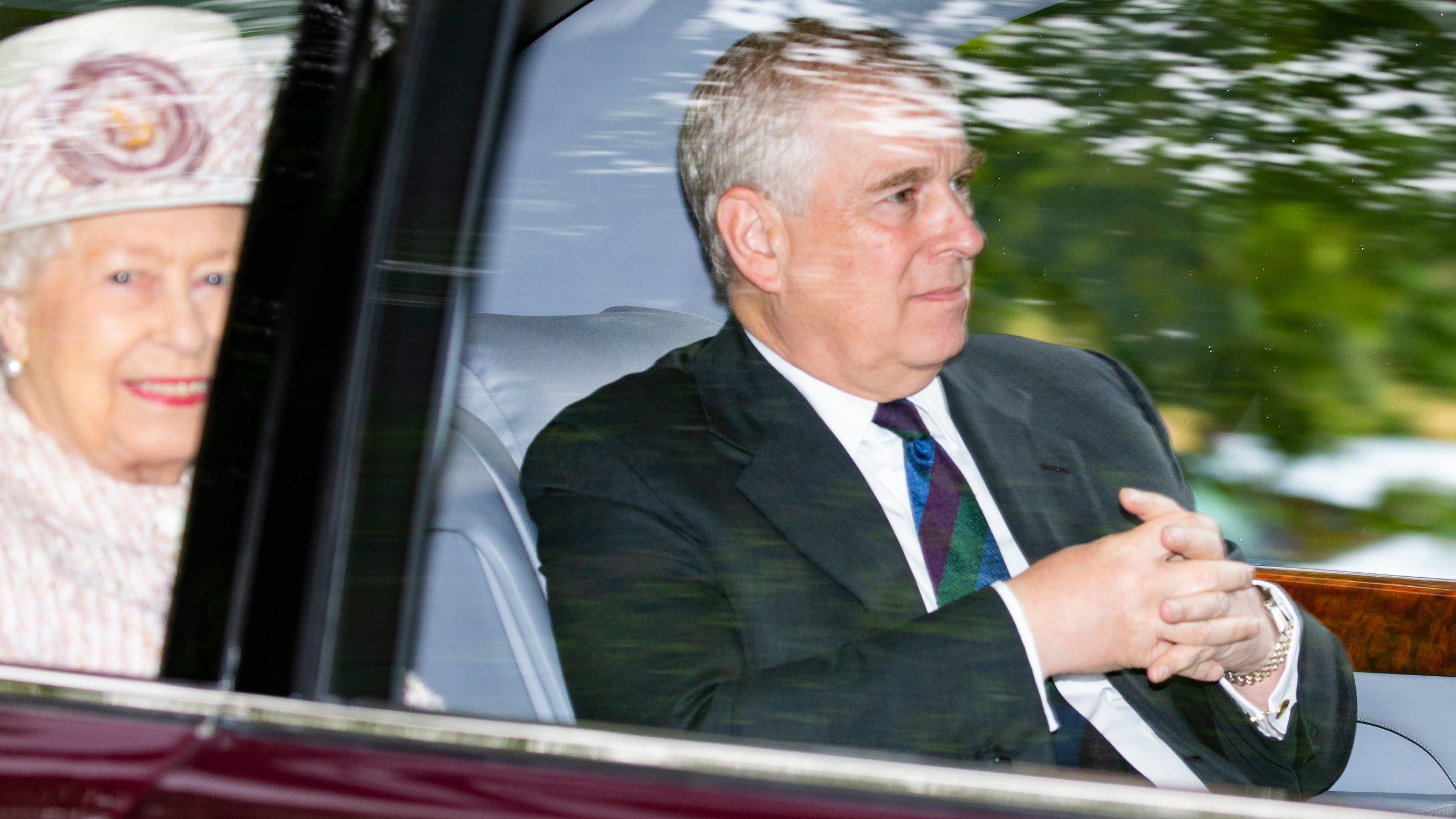 Prince Andrew, Duke of York, and his mother, Queen Elizabeth II, are driven from Crathie Kirk Church following a service on Aug. 11, 2019 in Crathie, Aberdeenshire. (Credit: Duncan McGlynn/Getty Images)