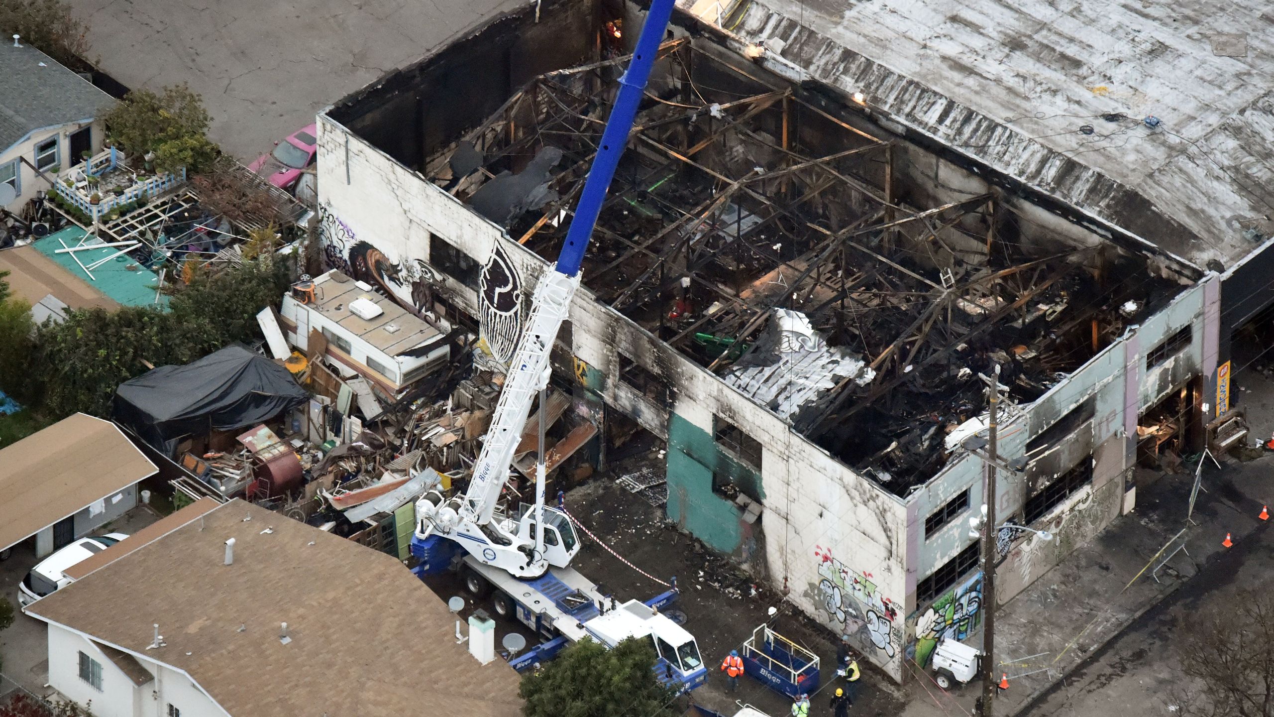 A crane is used to lift wreckage as part of search efforts in a fire-ravaged warehouse in Oakland on Dec. 5, 2016. (Credit: Josh Edelson / AFP / Getty Images)