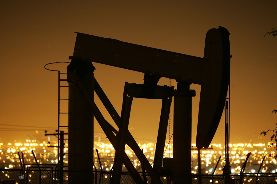 Pumps draw petroleum from oil wells through the night in Signal Hill on March 5, 2008. (Credit: by David McNew / Getty Images)