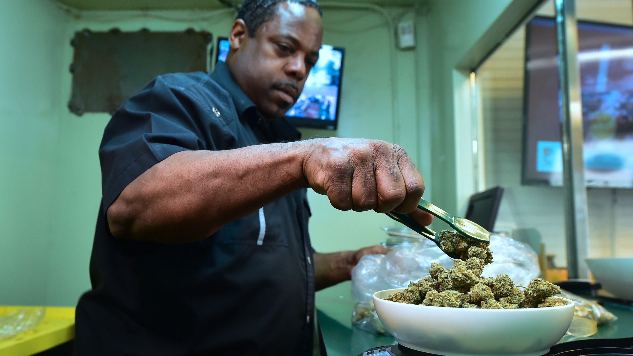 Eddie Irby weighs the marijuana at Virgil Grant's dispensary in Los Angeles, on Feb. 8, 2018. (Credit: FREDERIC J. BROWN/AFP/Getty Images)