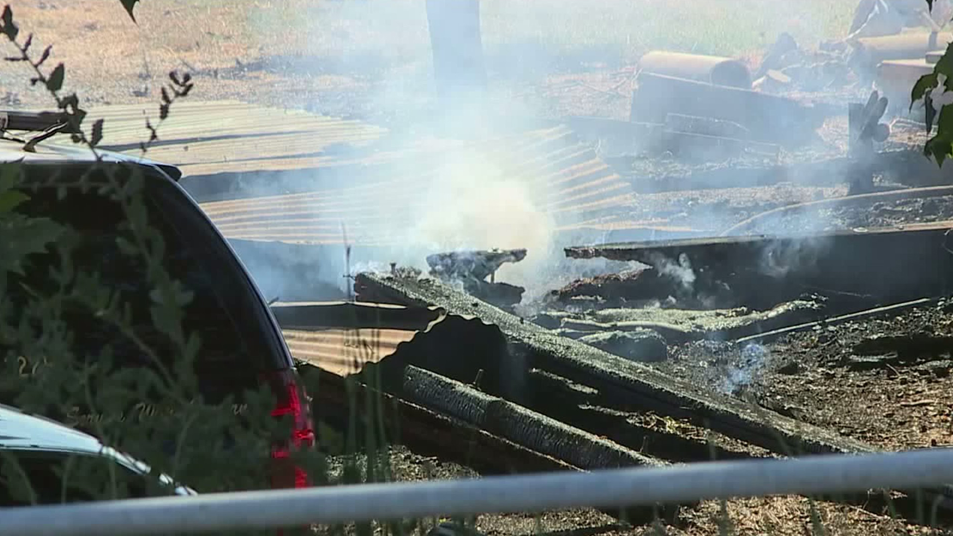 A burned down shed smolders at the scene where a 28-year-old man was intentionally set on fire in Sacramento County on Aug. 26, 2019. (Credit: KTXL)