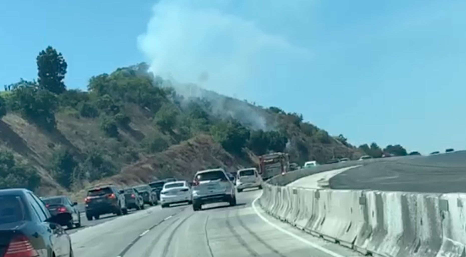 Smoke is seen on the hillside along the 10 Freeway in Covina on Aug. 17, 2019. (Credit: KTLA)